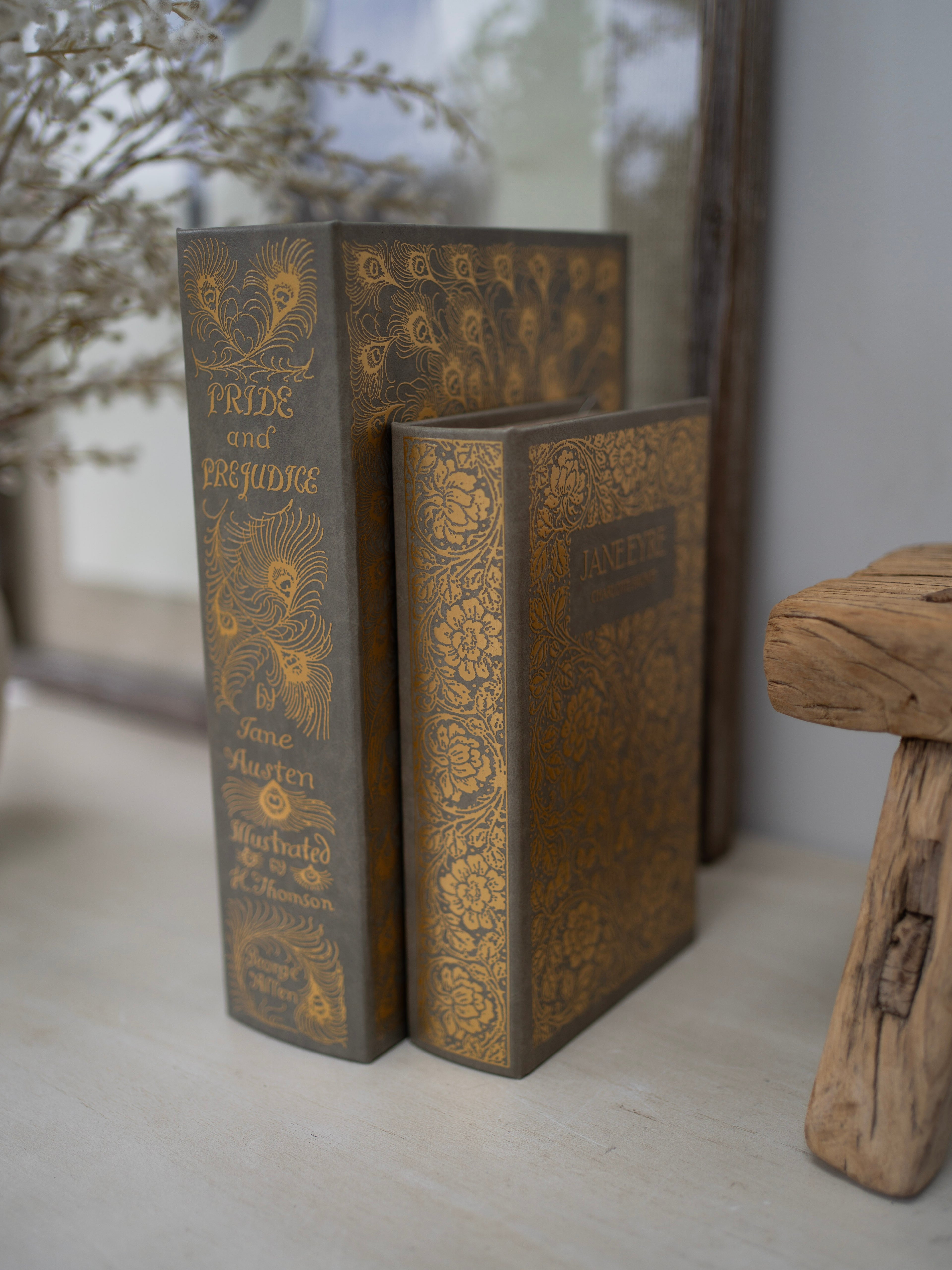 Decorative books with ornate gold designs on a neutral background