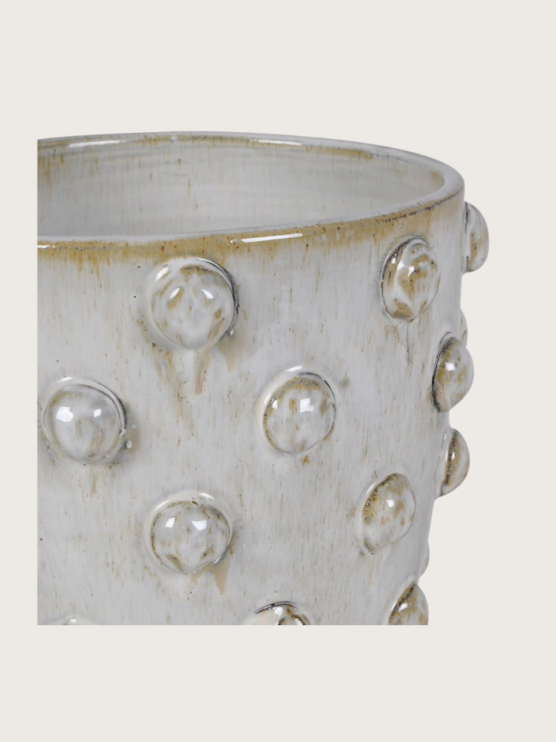 Ceramic pot with textured surface and raised circular elements on a white background