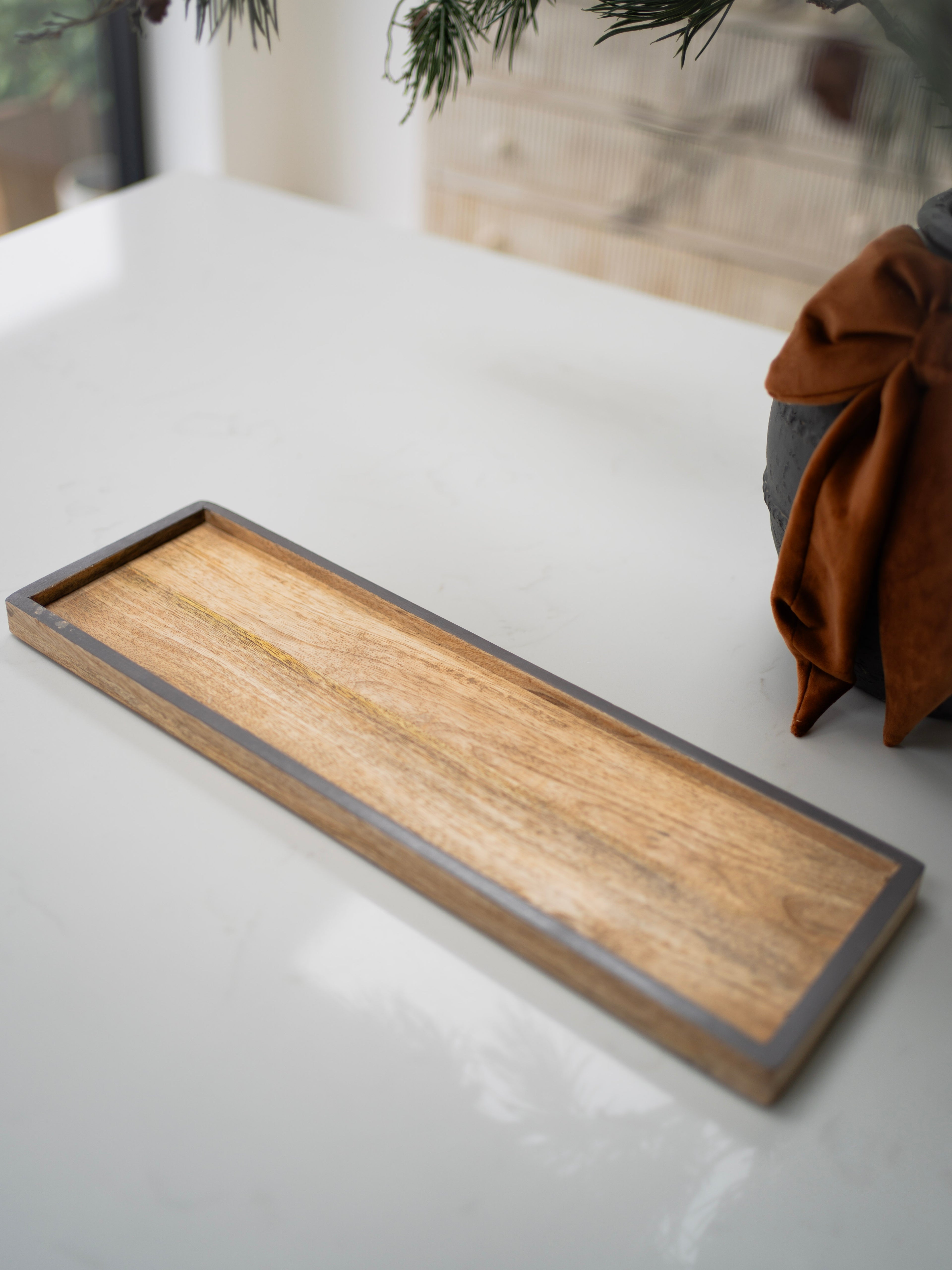 Wooden tray on a white surface with a blurred background