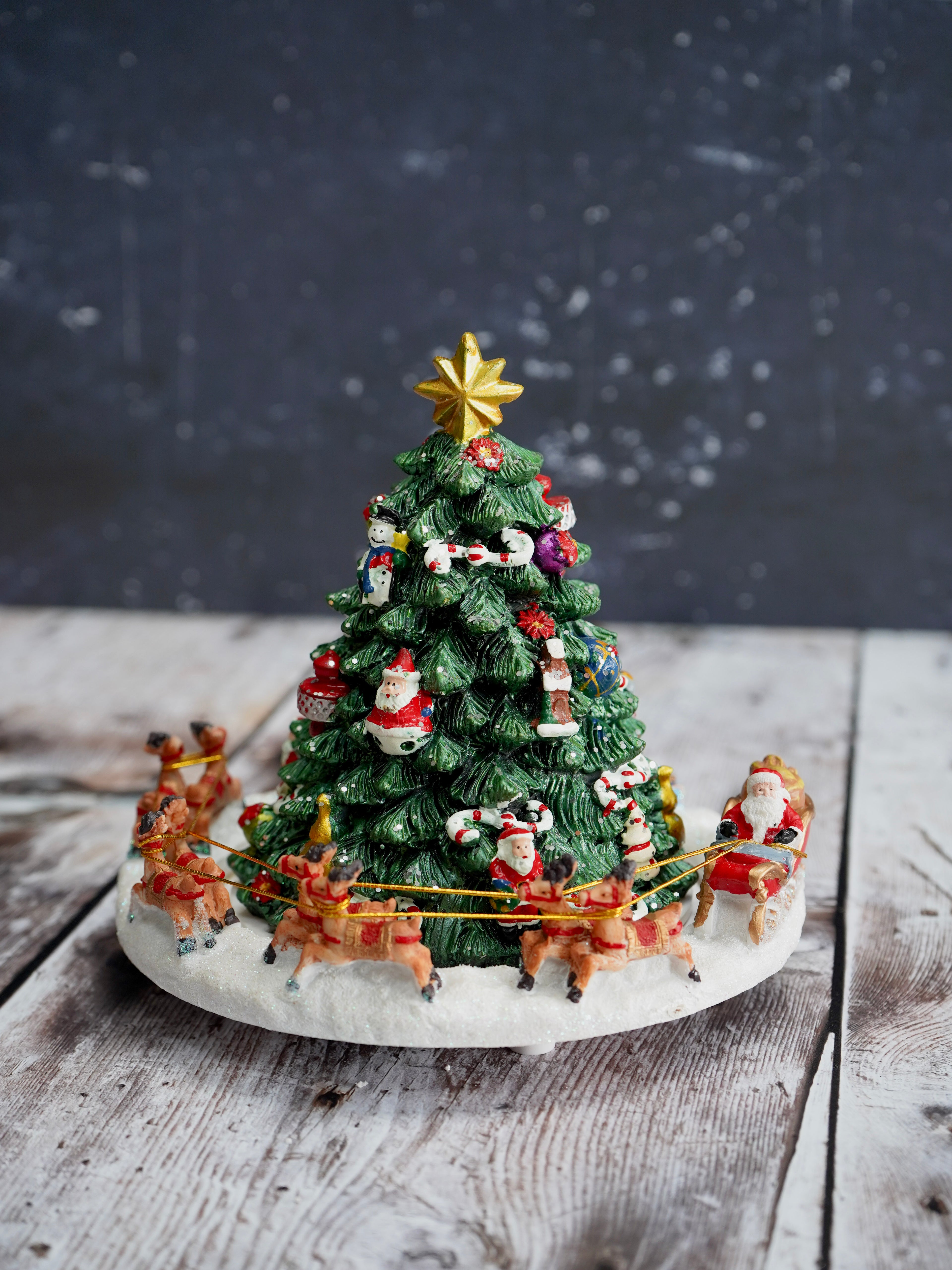 Decorative Christmas tree with Santa Claus and reindeer on a wooden surface