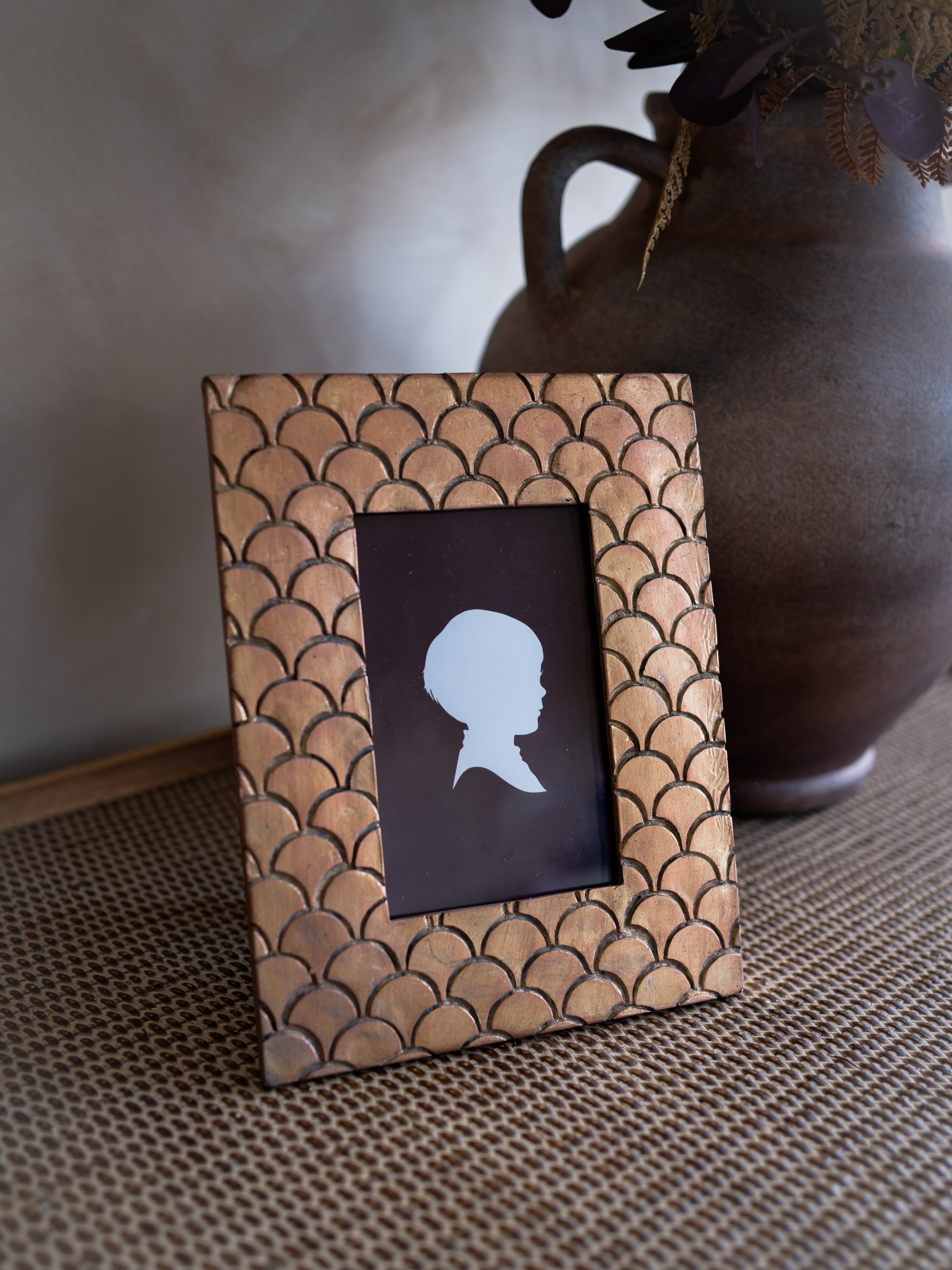 Decorative photo frame with fish scale pattern on a textured surface