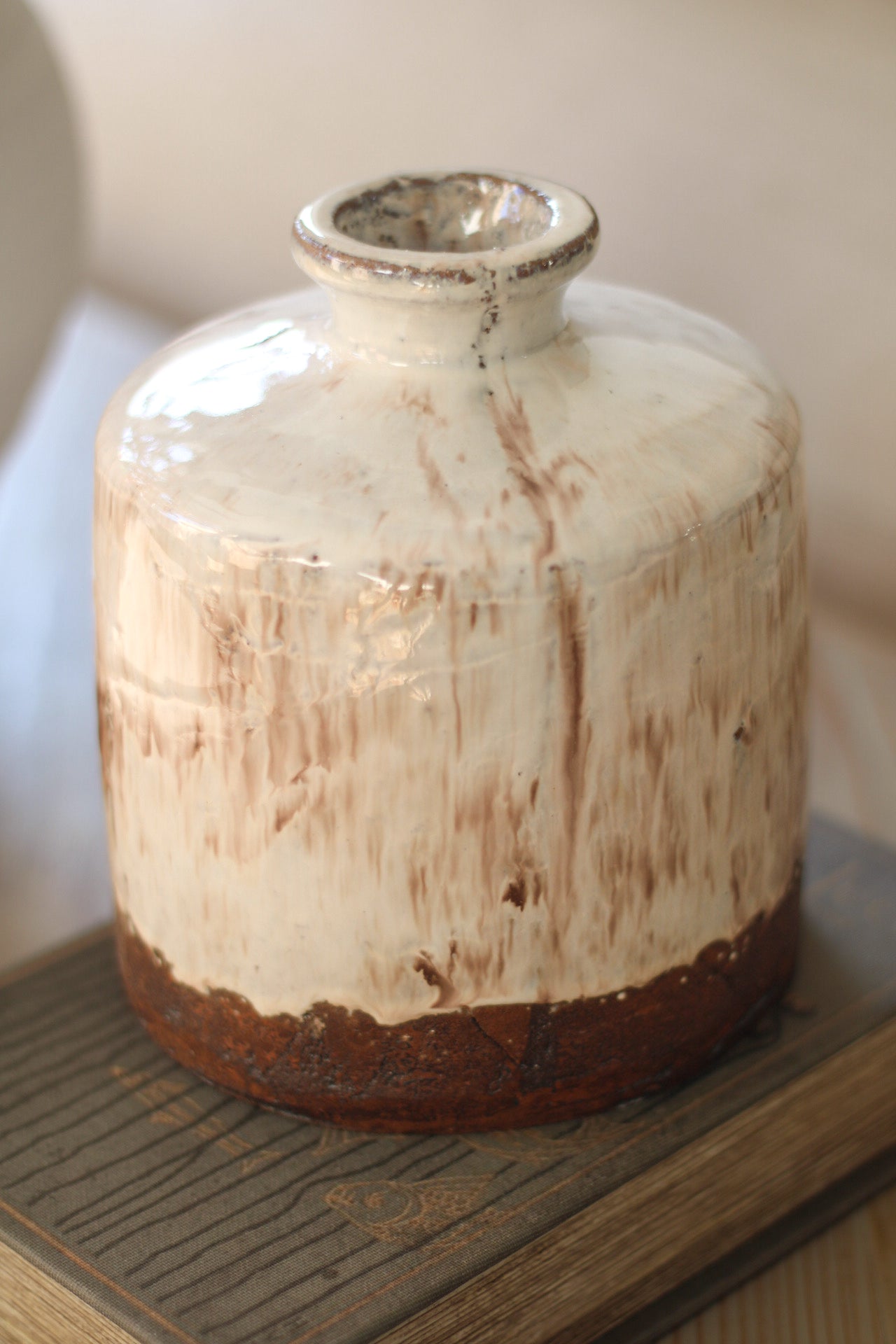 Vintage ceramic jar with a rustic finish on a wooden surface
