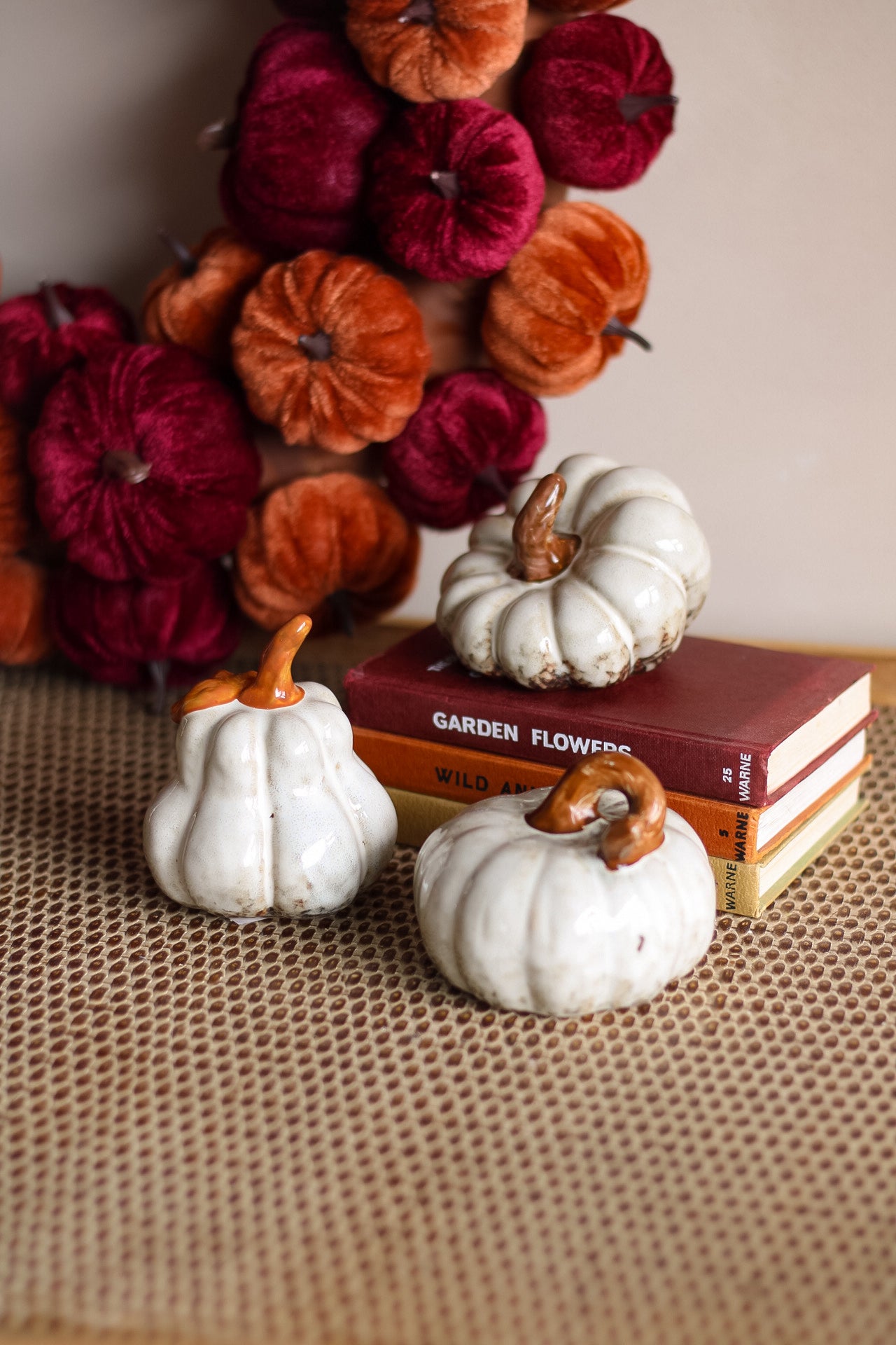 Decorative pumpkins on books with a background of colorful pumpkins.