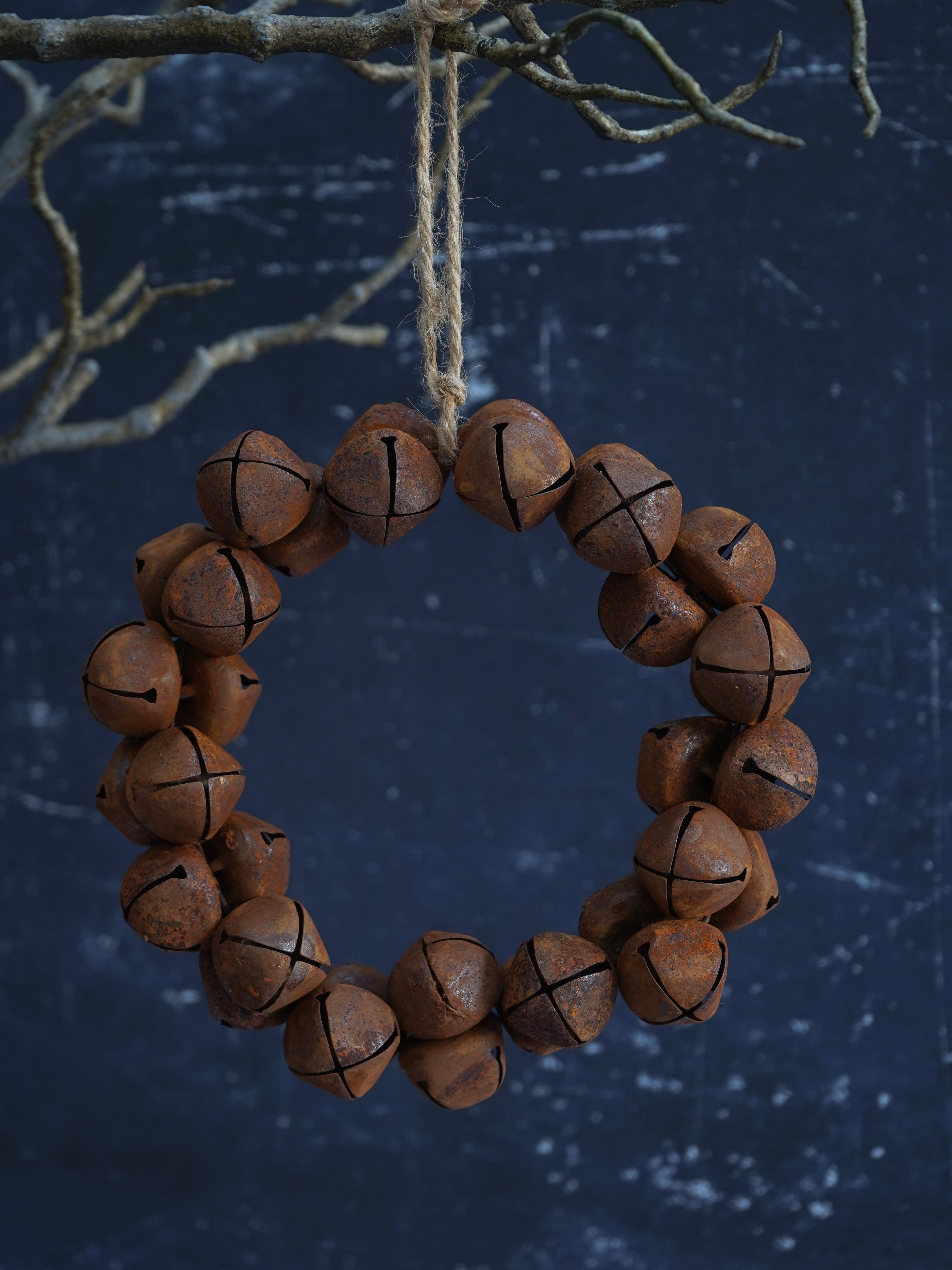 Decorative wreath made of brown jingle bells on a dark blue background