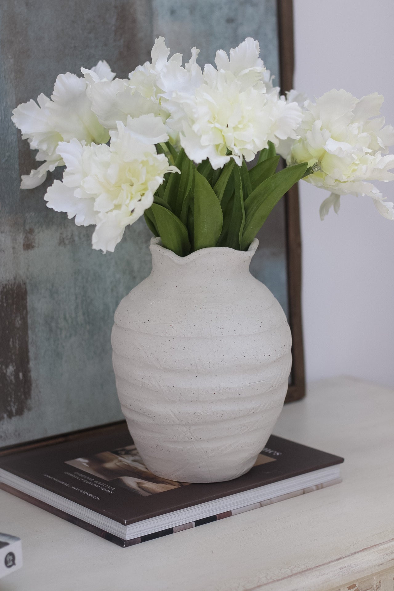 Rustic white ridged ceramic vase with faux frilly parrot white tulips