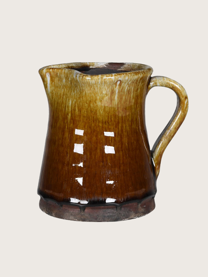 Brown ceramic pitcher on a light gray background