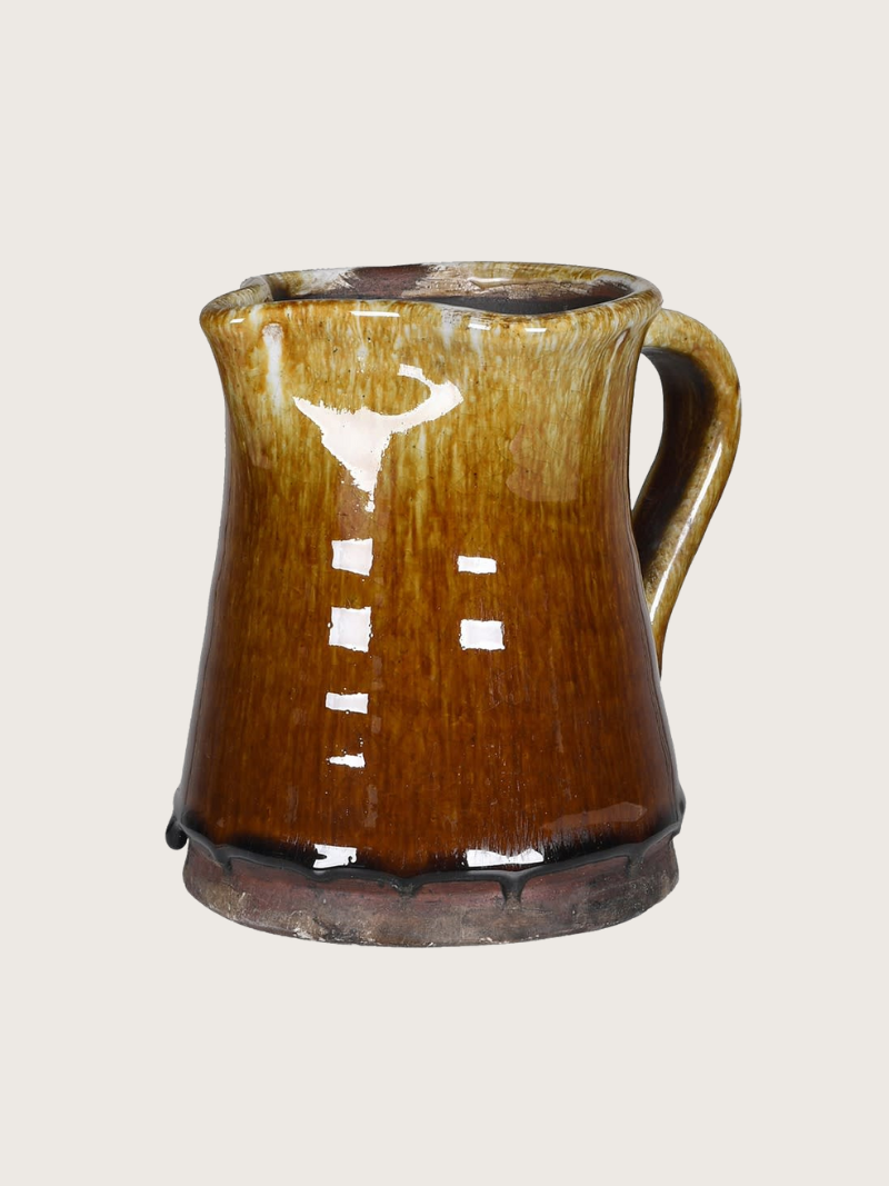 Brown ceramic pitcher on a light gray background