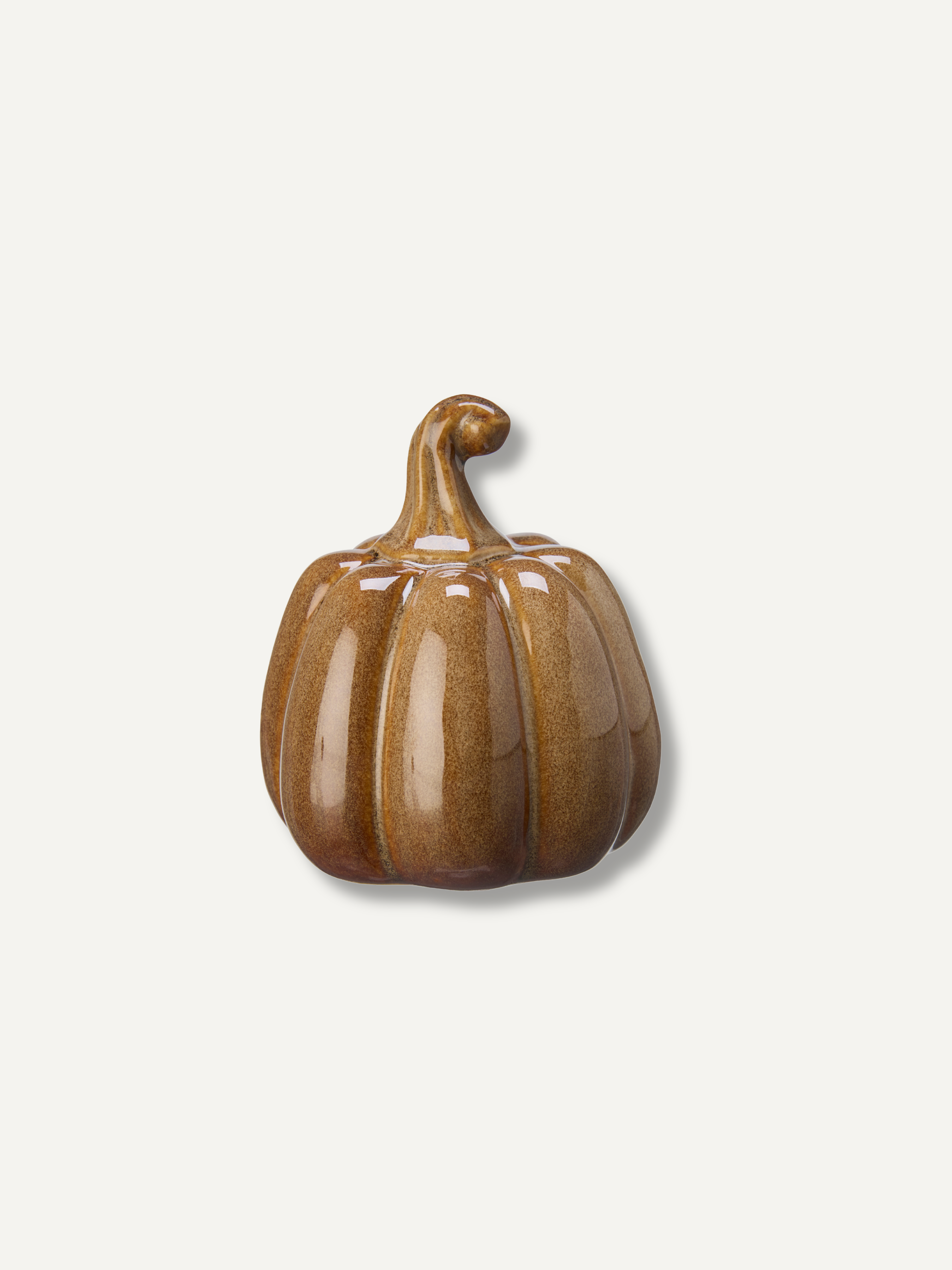 A small glazed ceramic pumpkin figurine in a warm brown color with a glossy finish, set against a plain off-white background.
