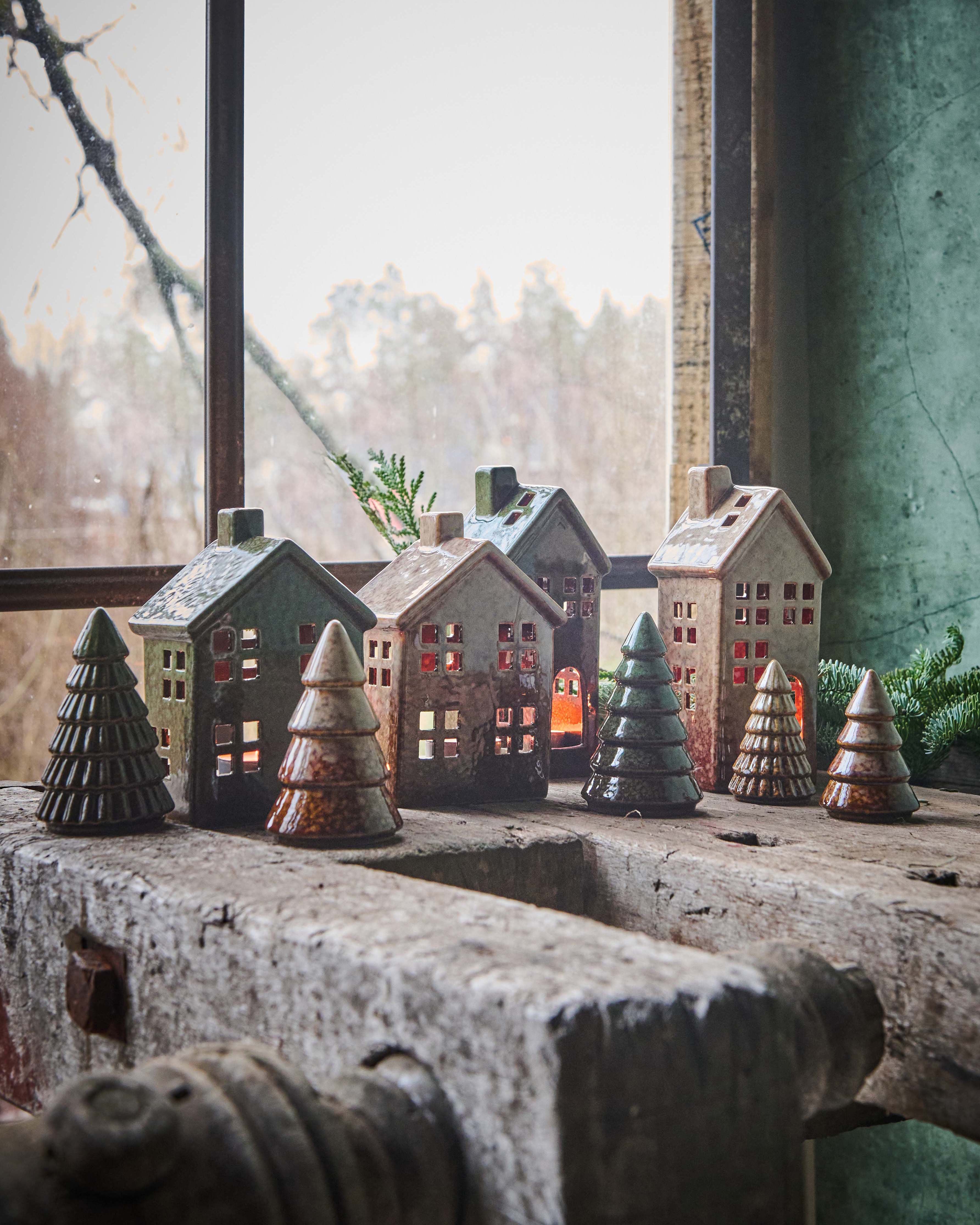 collection of reactive glazed trees and houses on rustic wooden bench
