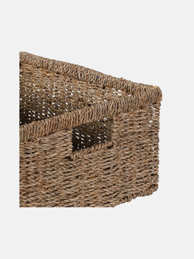 Woven seagrass storage basket with a lid on a white background