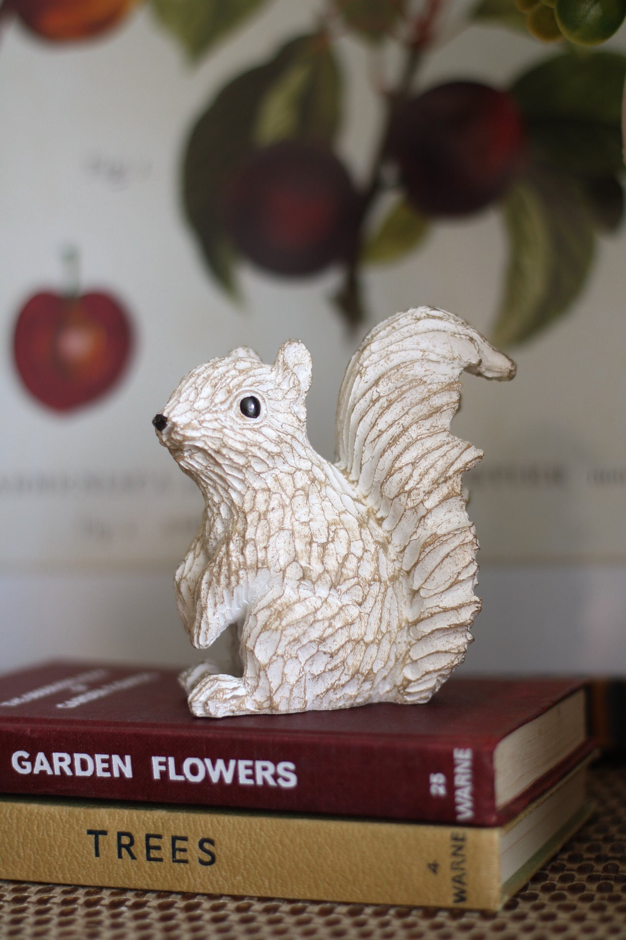 Decorative squirrel figurine on top of books with a blurred background