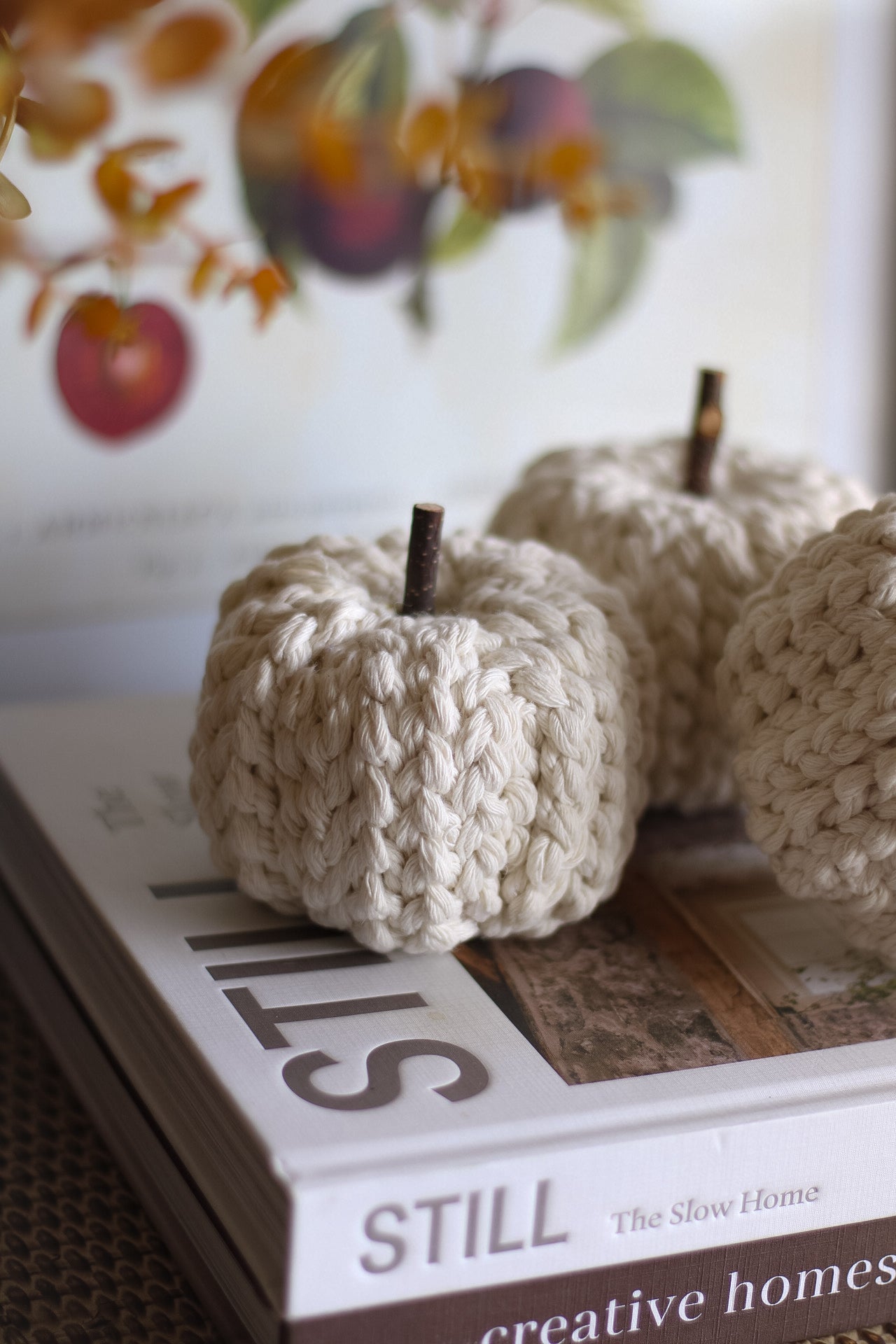 Cream knitted pumpkins on a book titled &