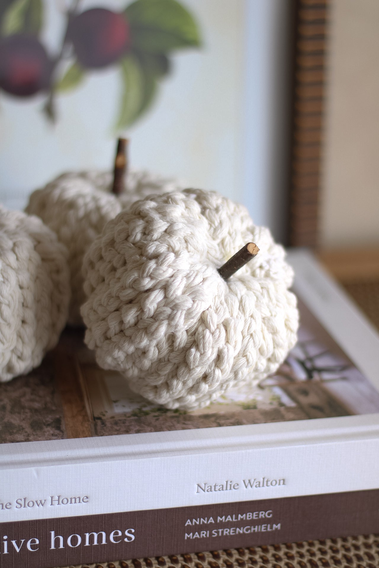 Knitted apples on a book with a blurred background