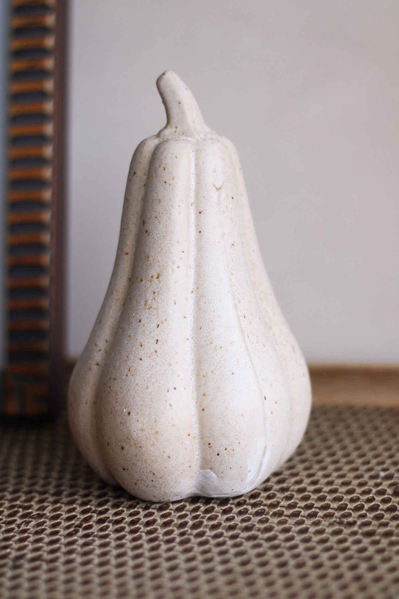 White ceramic squash on a textured surface with a neutral background