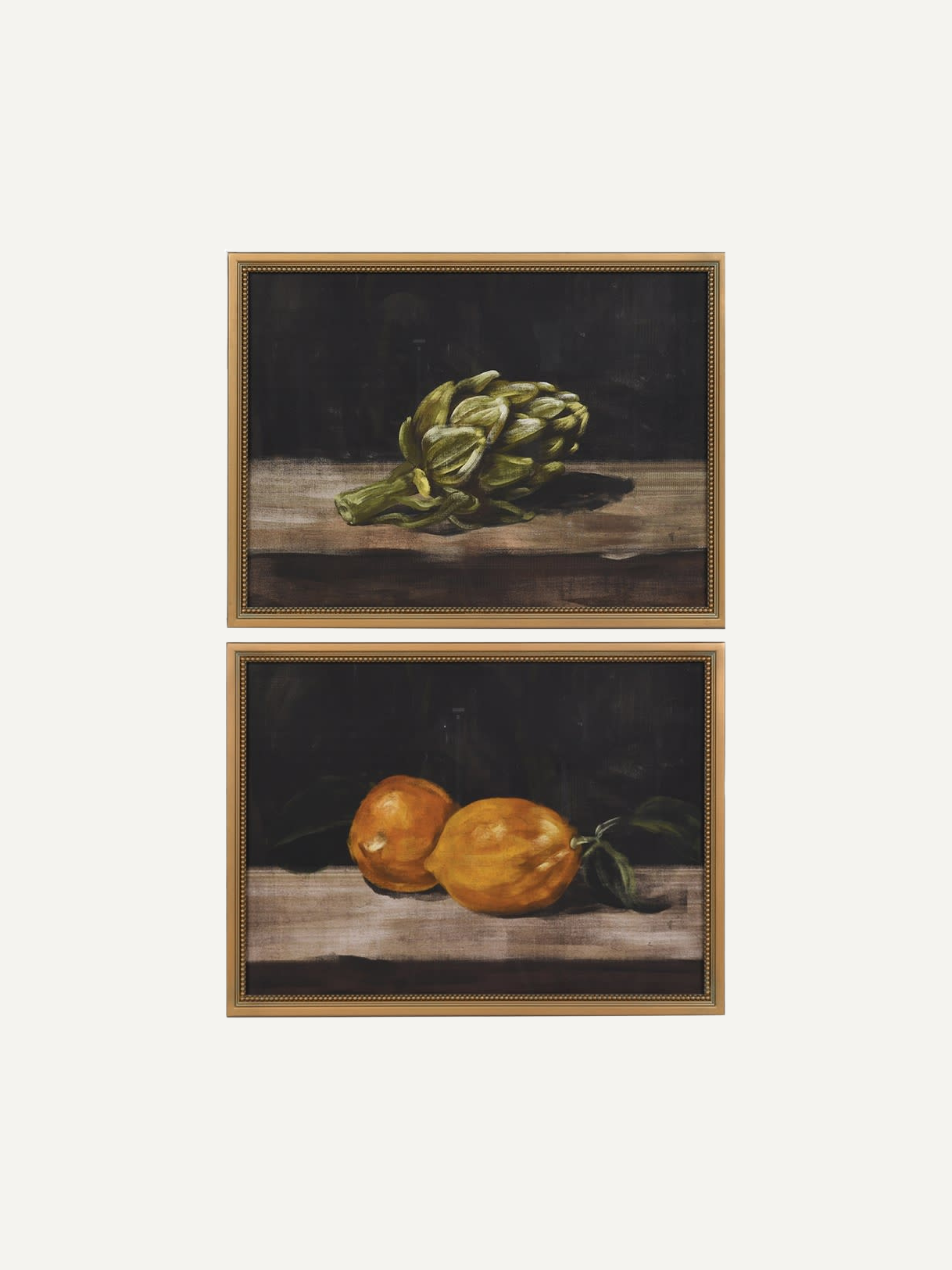 Two framed still life paintings of artichokes and lemons on a white background