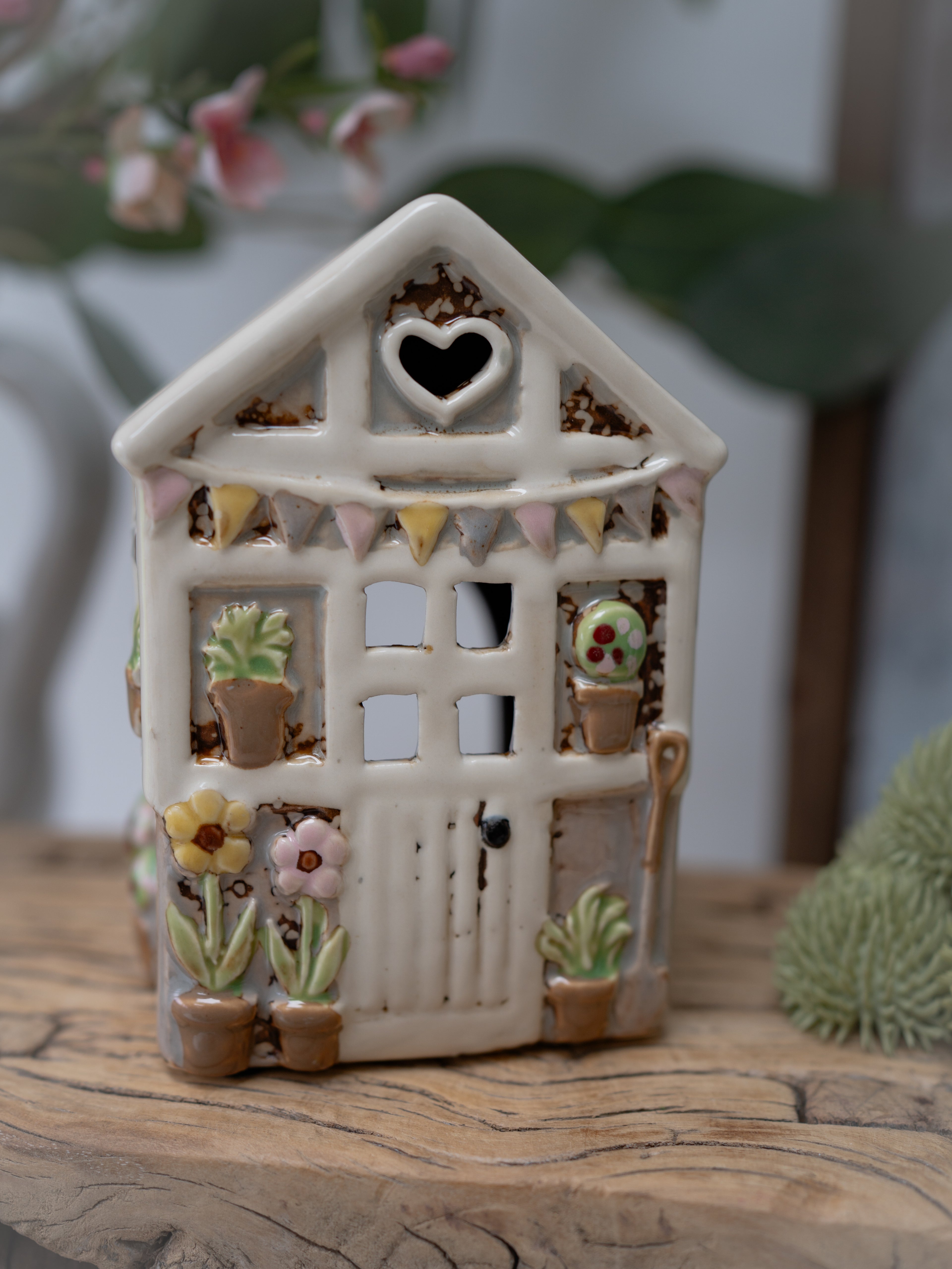 Small ceramic house with decorative elements on a wooden surface