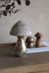 Decorative copper mushrooms on a textured surface with a neutral background
