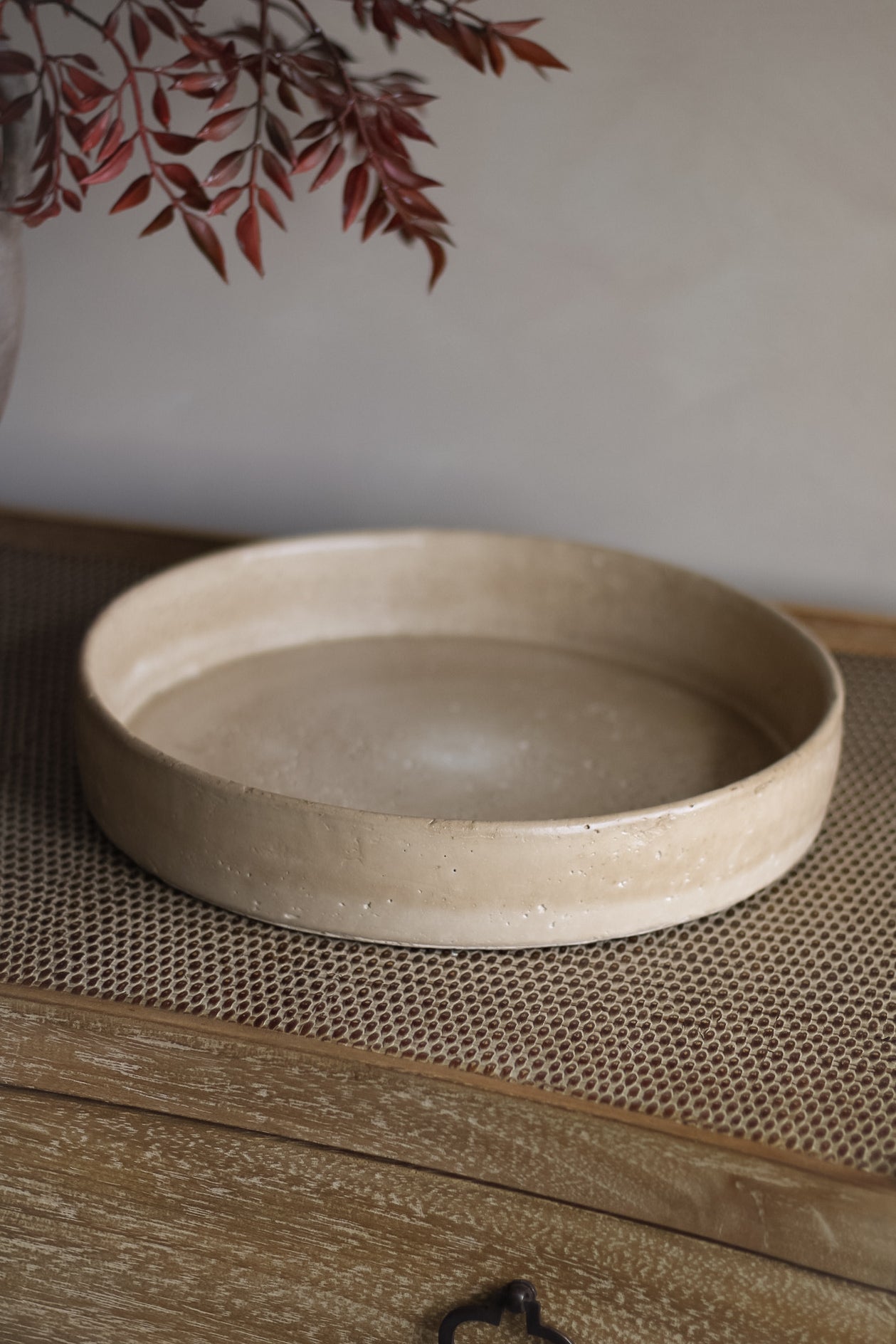 Beige ceramic tray on a textured surface with a blurred background