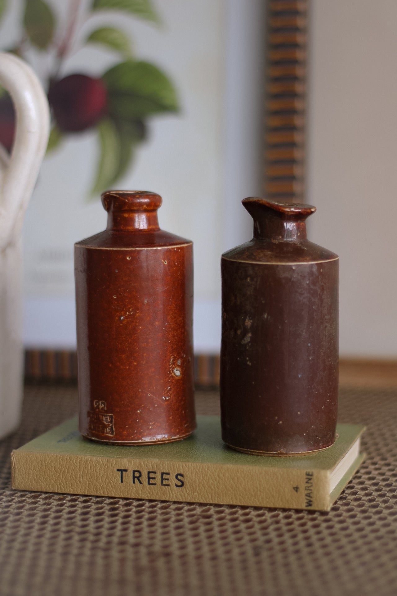 Two brown ceramic bottles on a book titled &