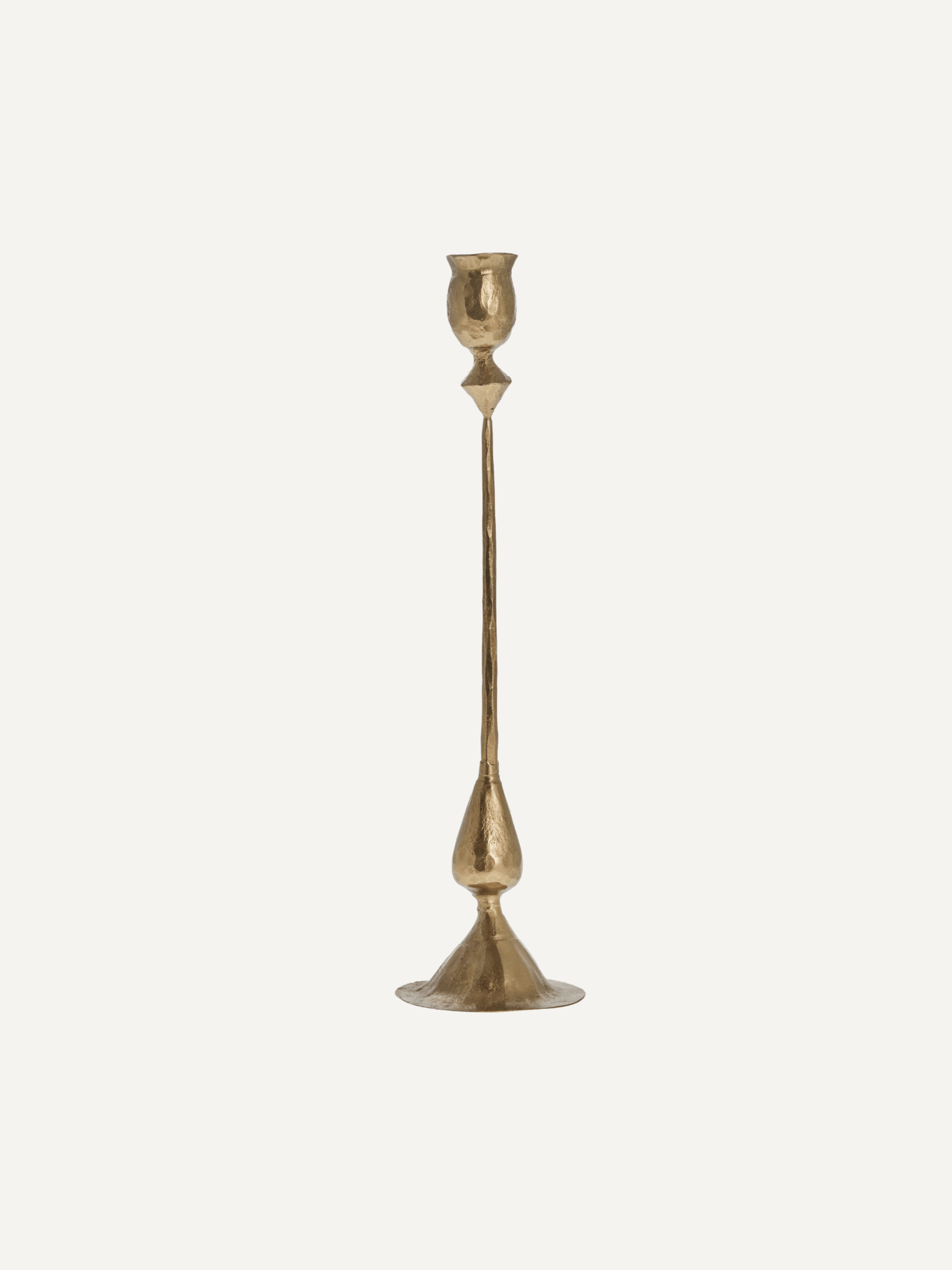 Gold candle stick on a light beige background