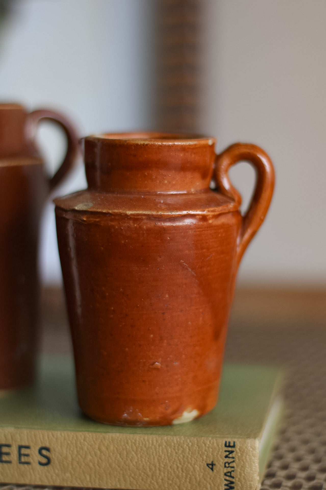 Brown ceramic jug on a surface with a blurred background