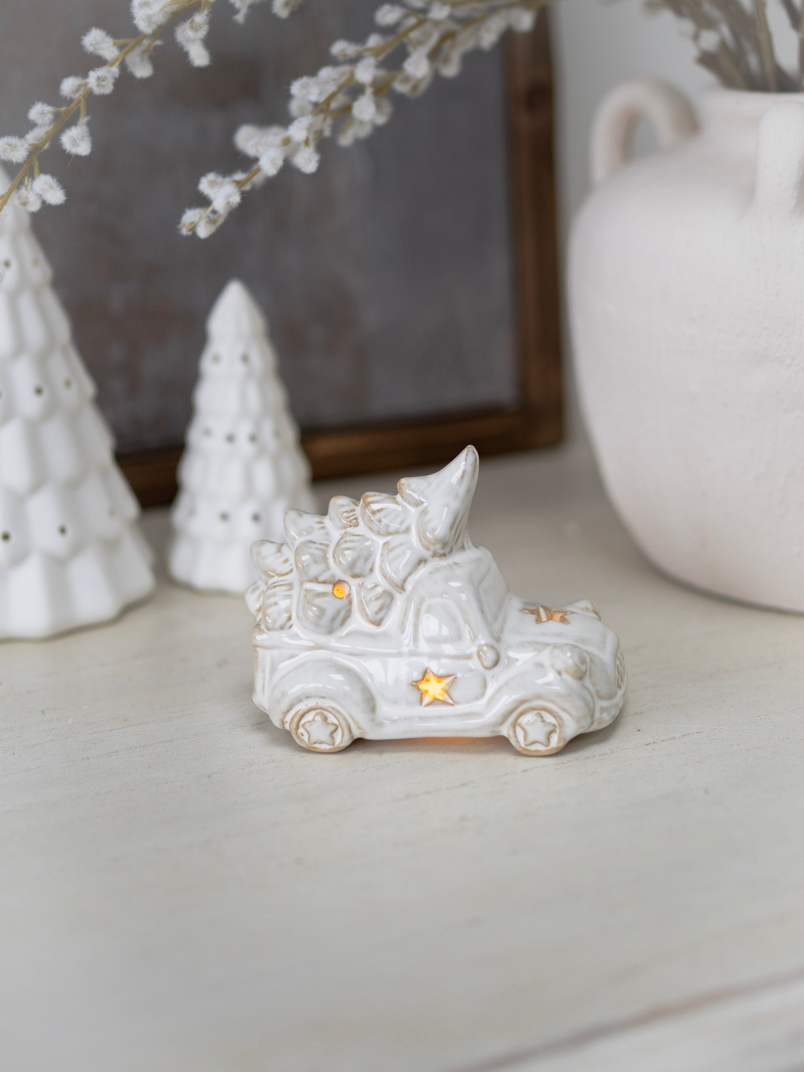 Decorative white ceramic cat figurine with a star on a neutral background