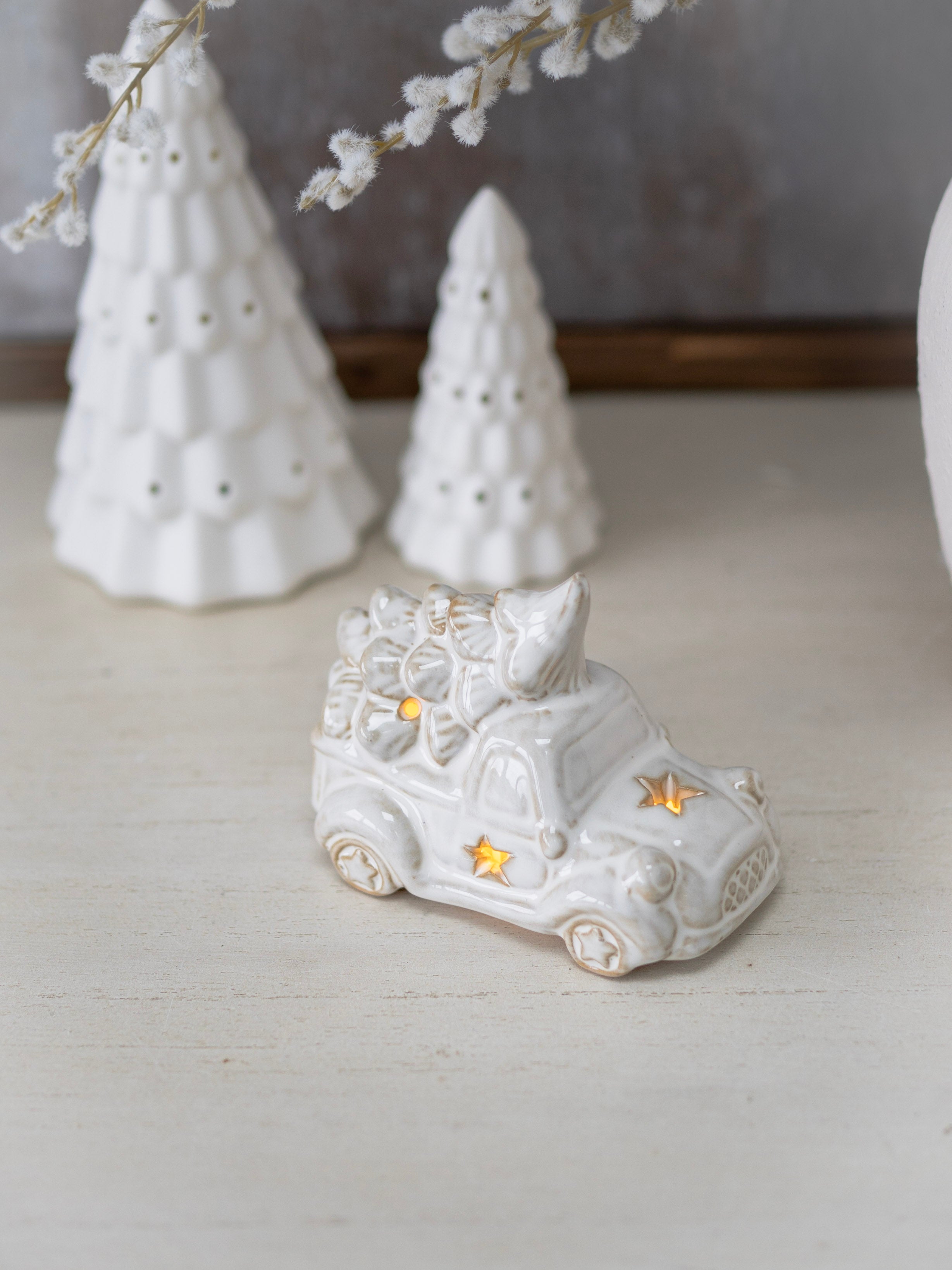 White ceramic boot with decorative elements on a light surface