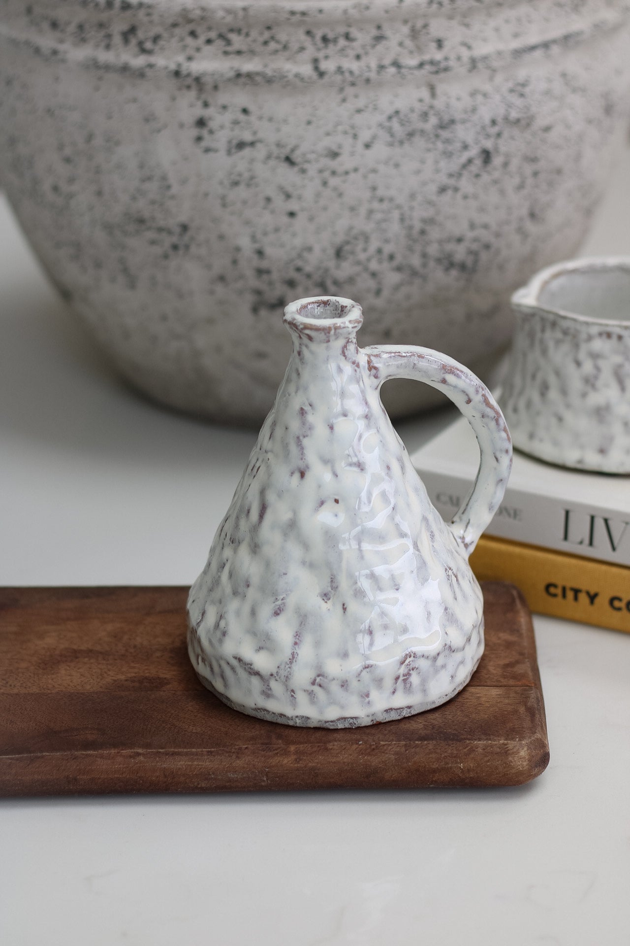 Speckled mottled terracotta pot on a wooden board with a blurred background