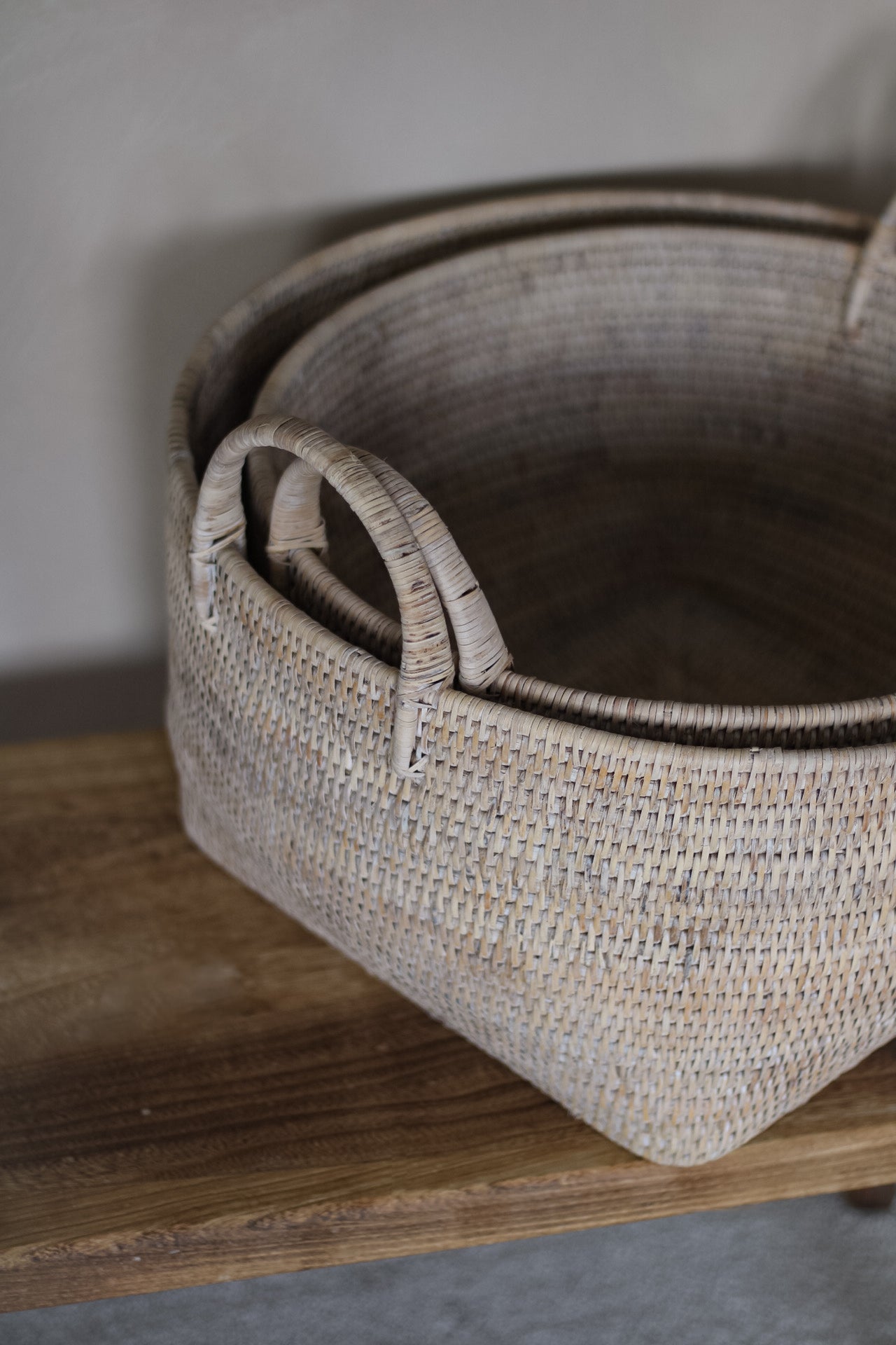 Woven basket with handles on a wooden surface