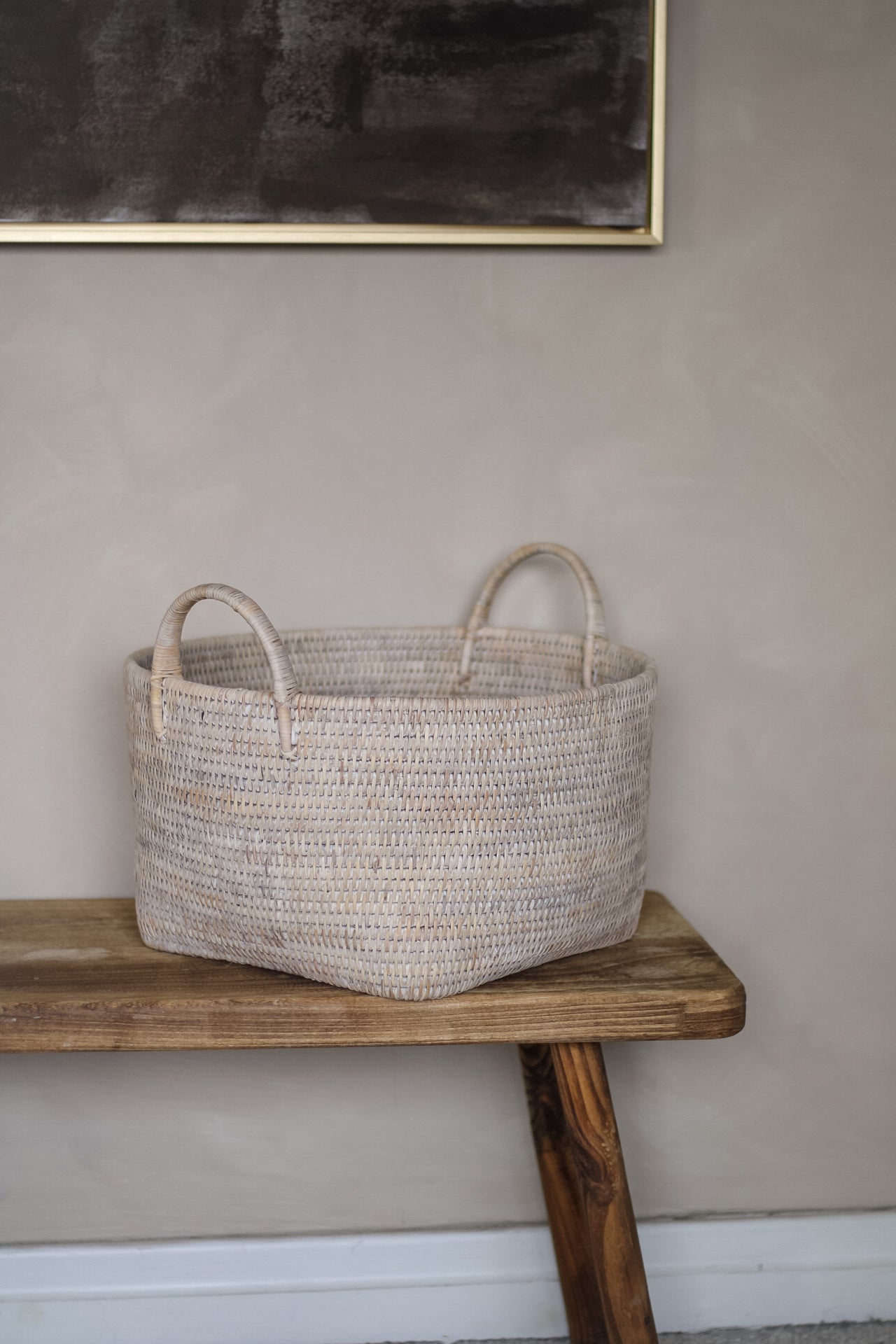 Woven basket on a wooden table against a plain wall