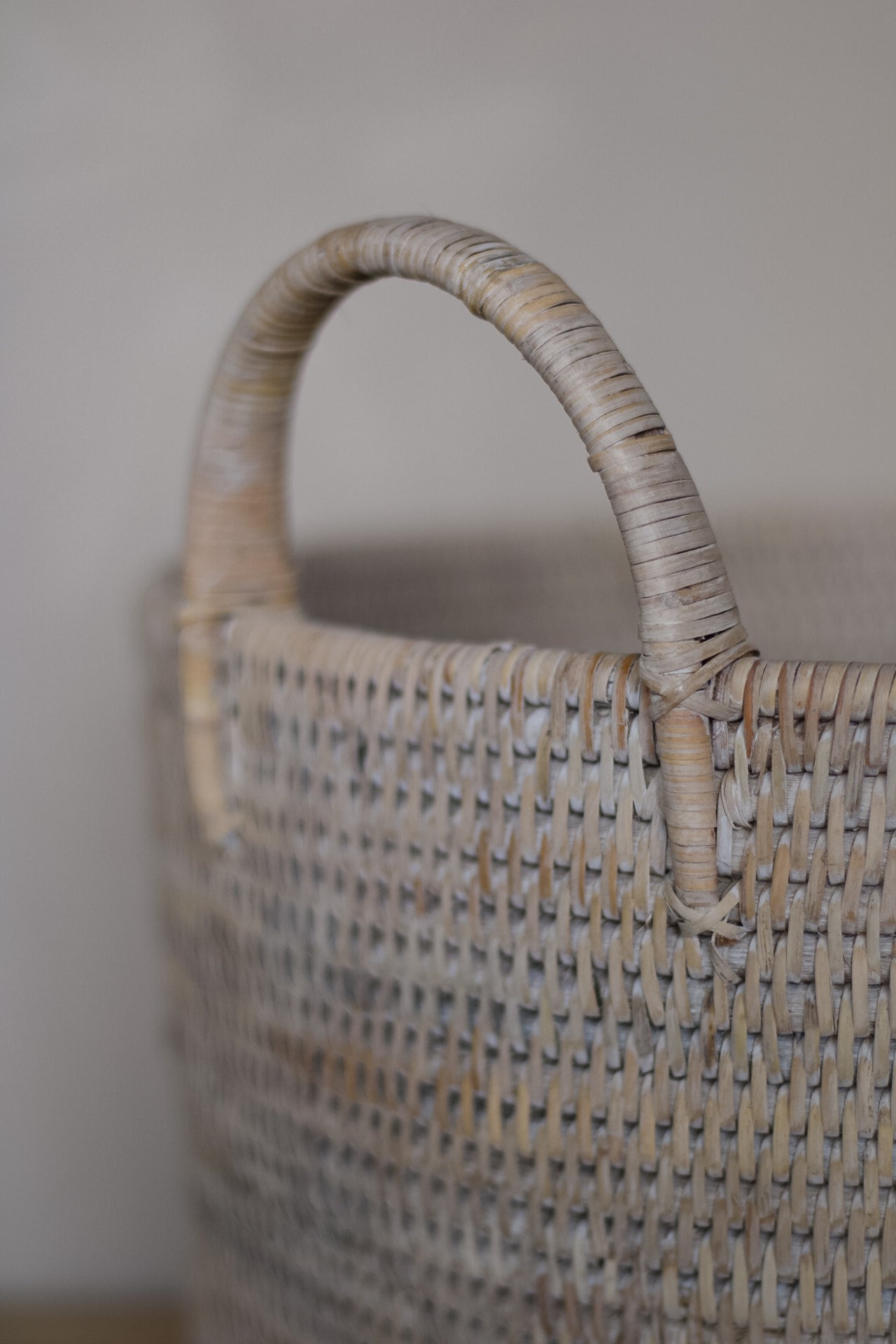Woven basket with a handle on a neutral background