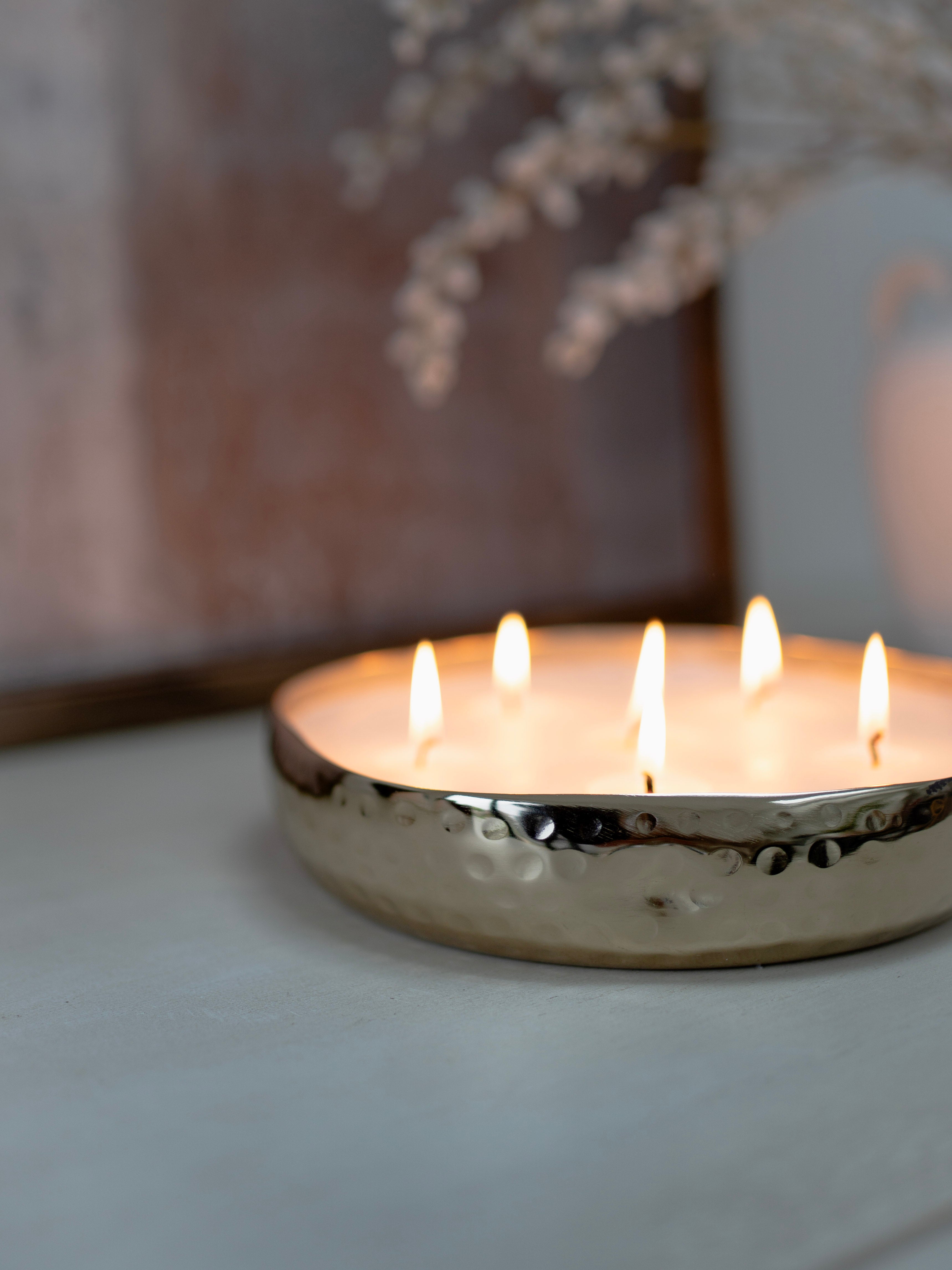 Candle holder with five burning candles on a neutral background