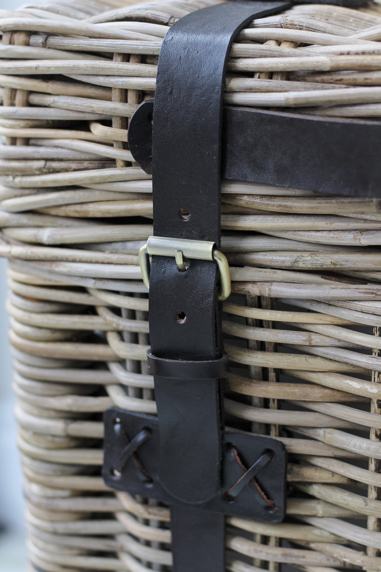 close up of rattan end table with leather straps