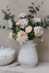 rustic white vase filled with powder pink faux flowers and blush eucalyptus