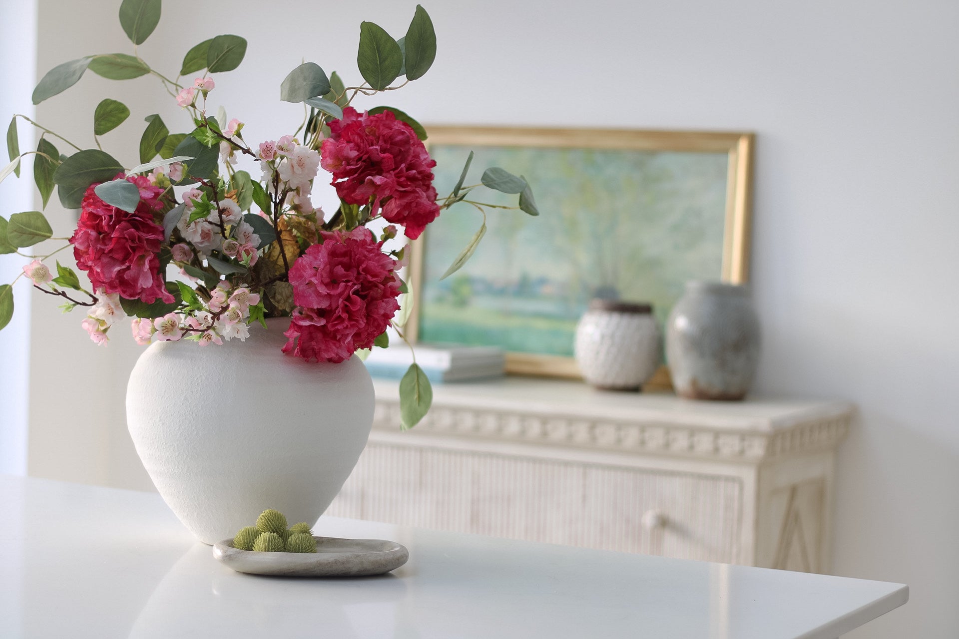 spring inspired faux floral arrangement in white ceramic vase