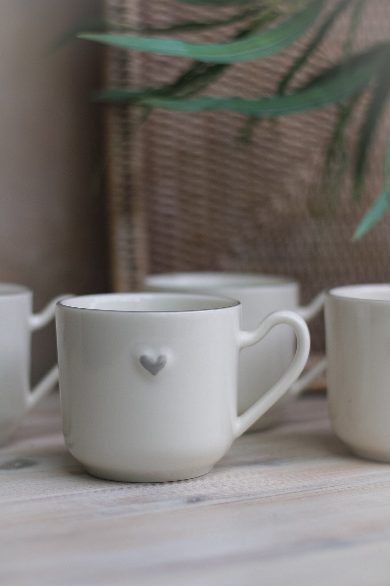 up close of white ceramic mug with embossed grey heart