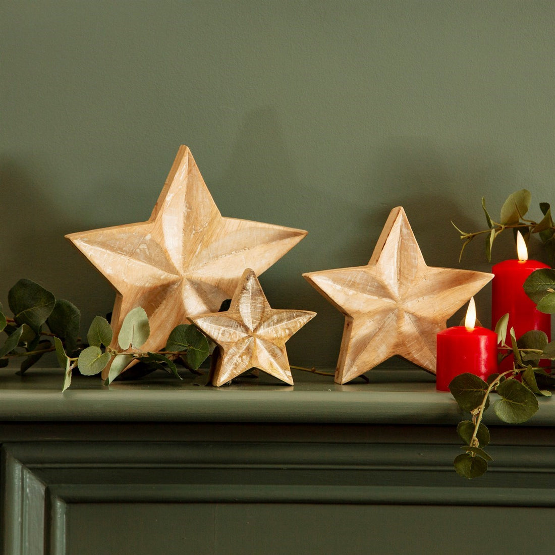 Three chunky wooden stars with etched line details