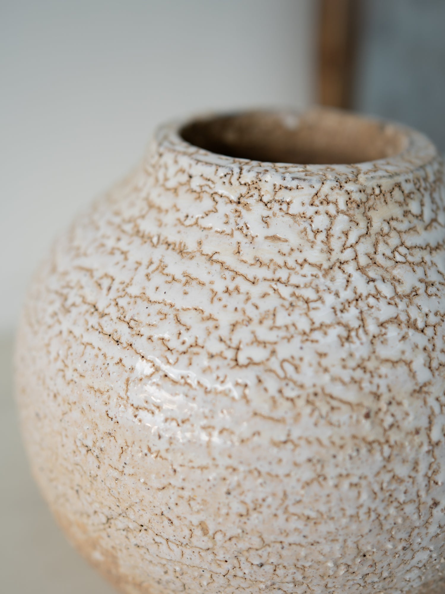 Close-up of a textured ceramic vase with a blurred background