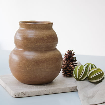 round brown vase on travertine board 