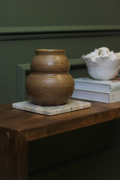brown vase on wooden sideboard 