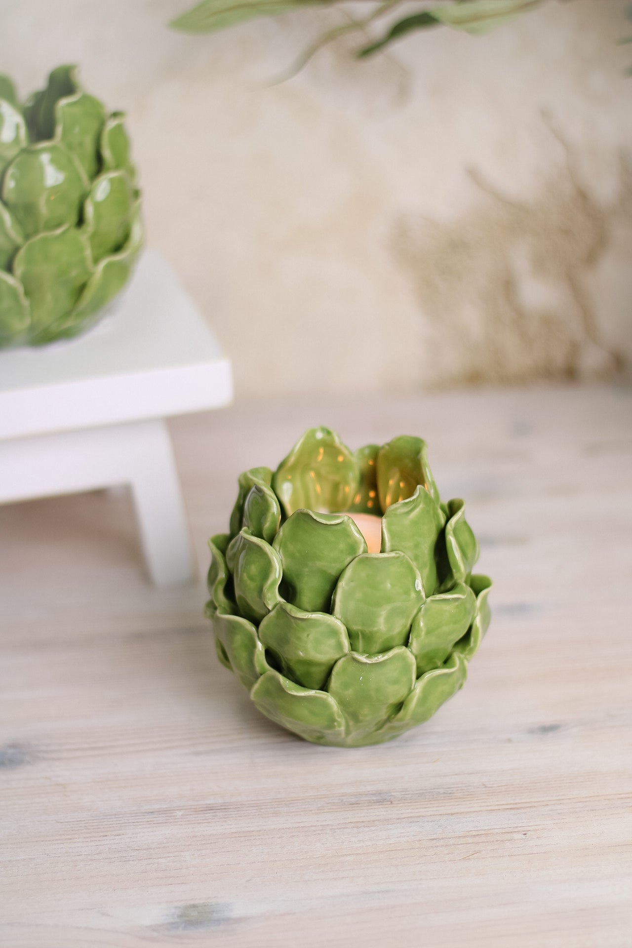 close up of green ceramic artichoke tea light holder on worktop