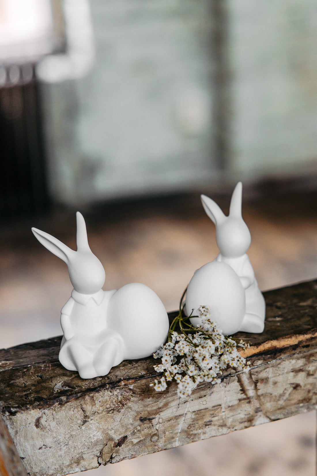 two matt white sitting bunnies with eggs