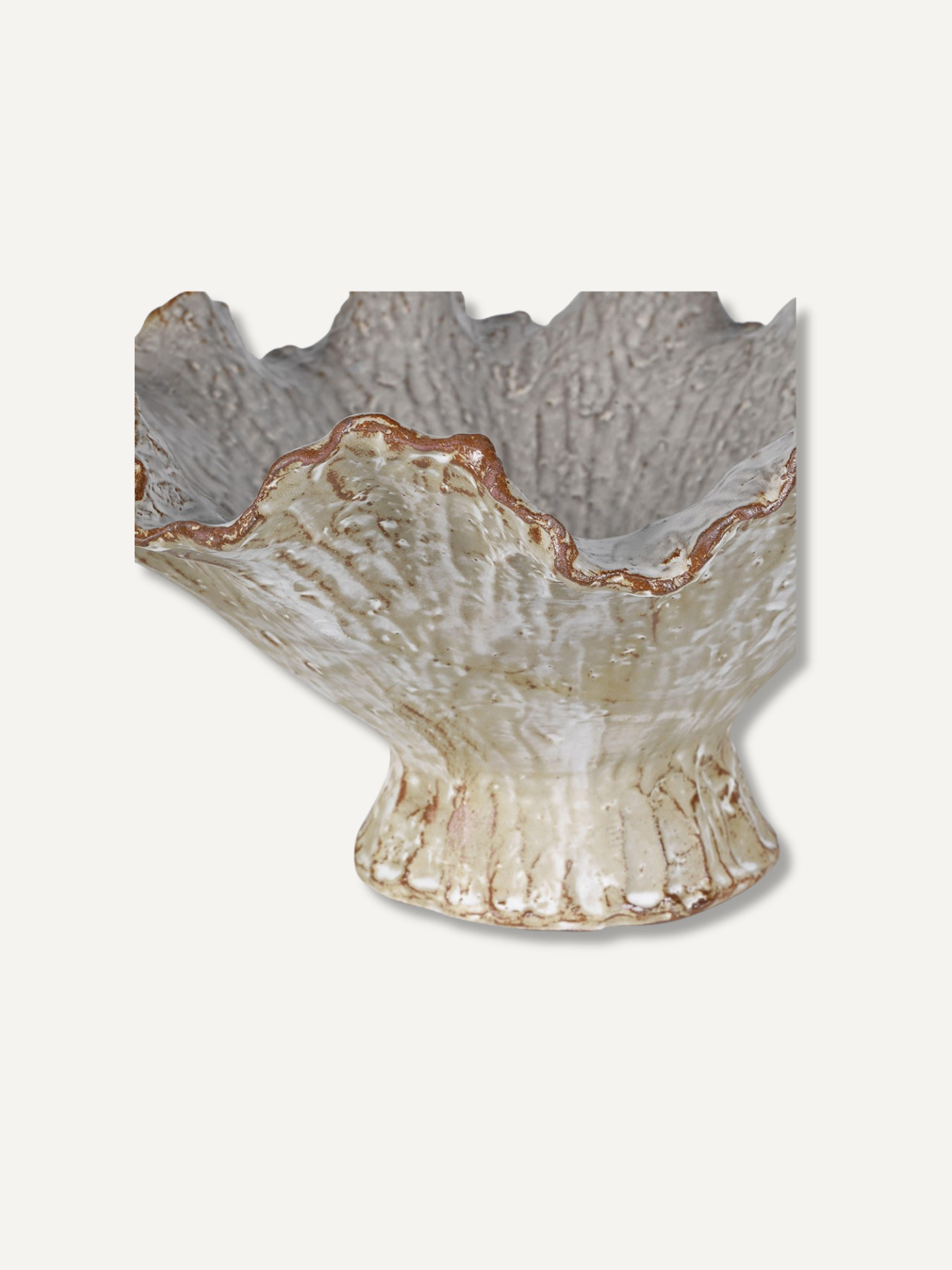 A textured ceramic pedestal bowl with a flared, scalloped rim, featuring a mottled cream and beige glaze with subtle brown accents, shown against a solid off-white background.