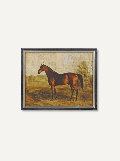A framed vintage-style painting depicting a brown horse standing in an outdoor landscape, mounted on a light off-white wall.