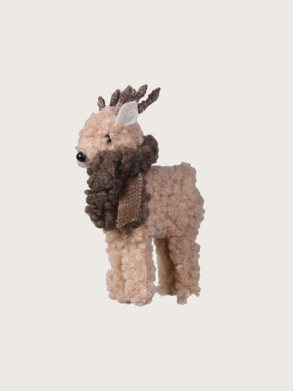 Plush toy deer with a scarf on a light gray background