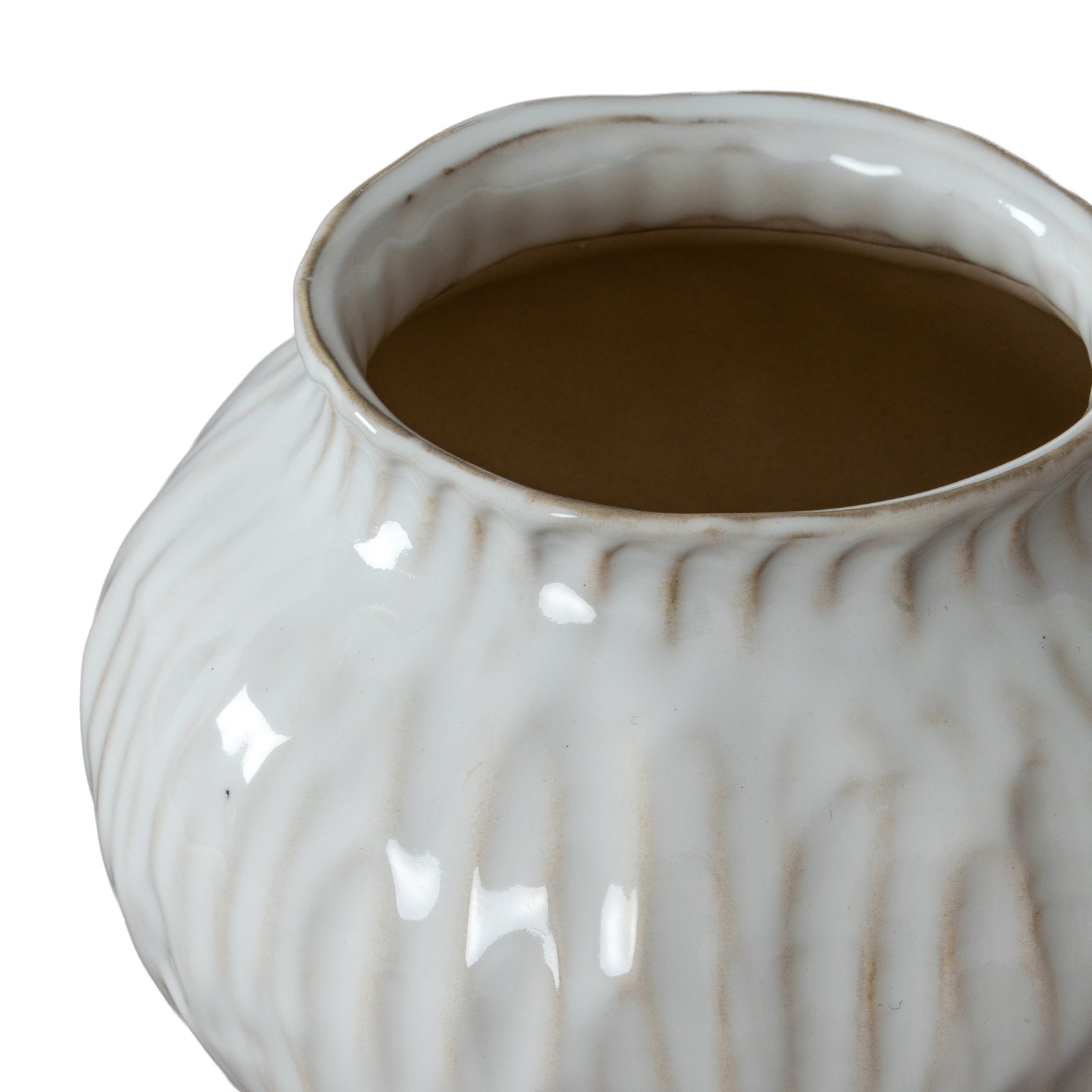 White ceramic pot with textured surface containing a brown liquid on a white background