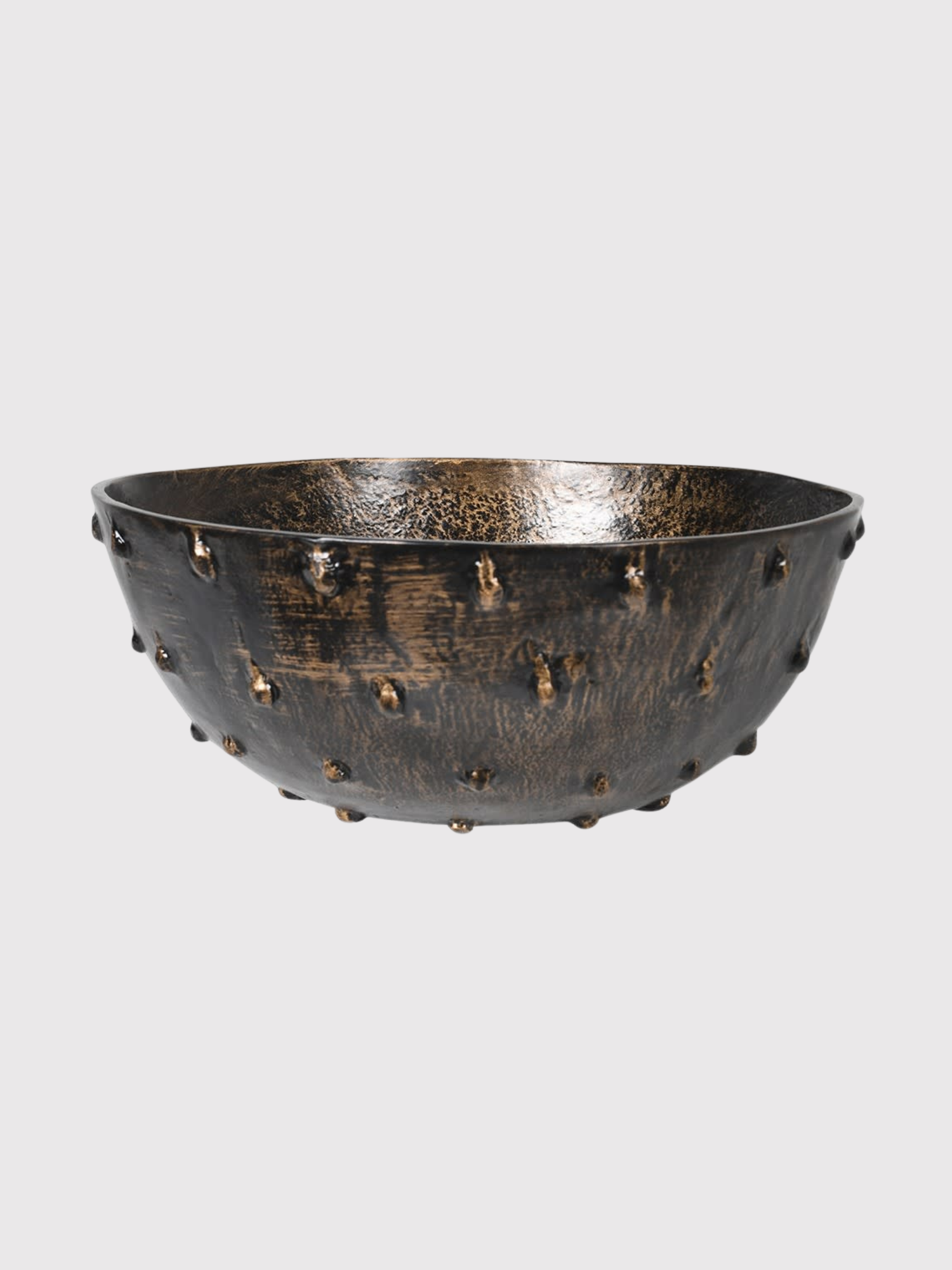 Decorative bowl with textured surface and small studs on a light gray background