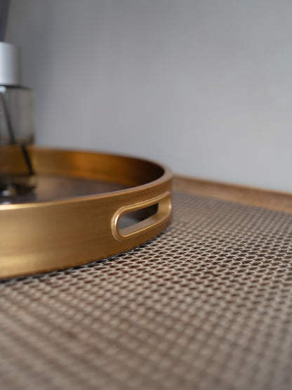 Gold tray on a textured surface with a neutral background
