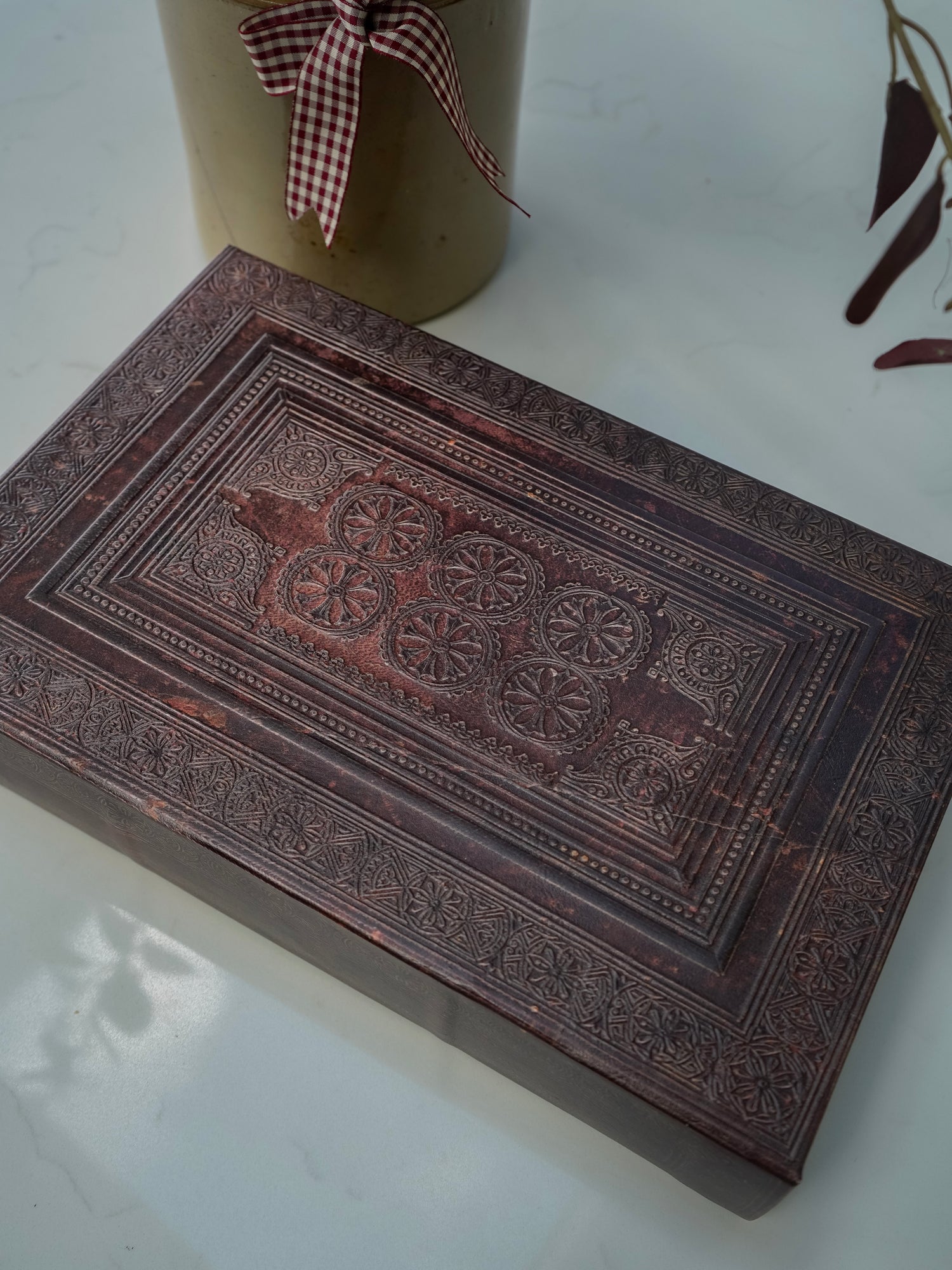 Decorative storage book box with intricate carvings on a white surface