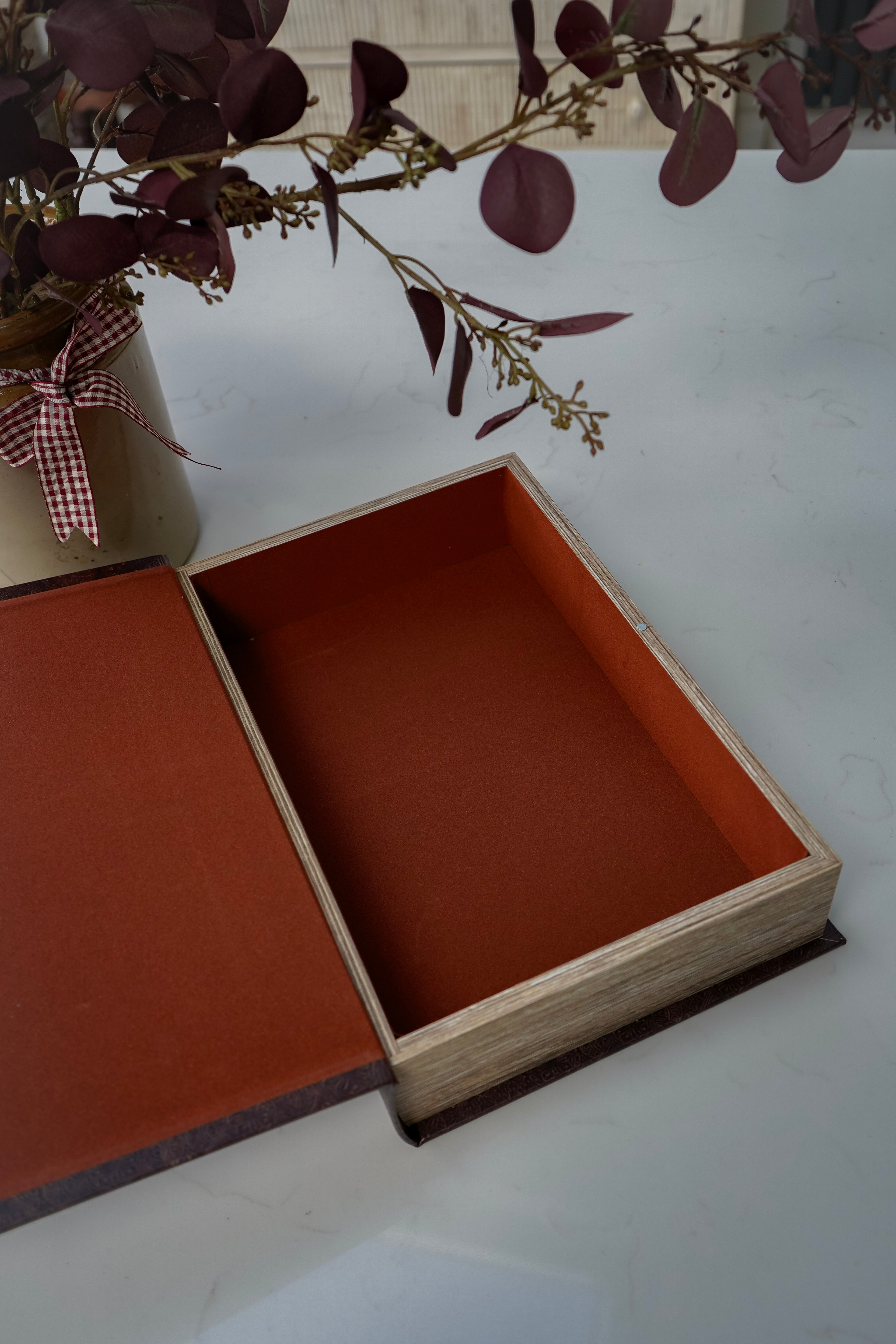 Open brown faux leather-bound book with a white background